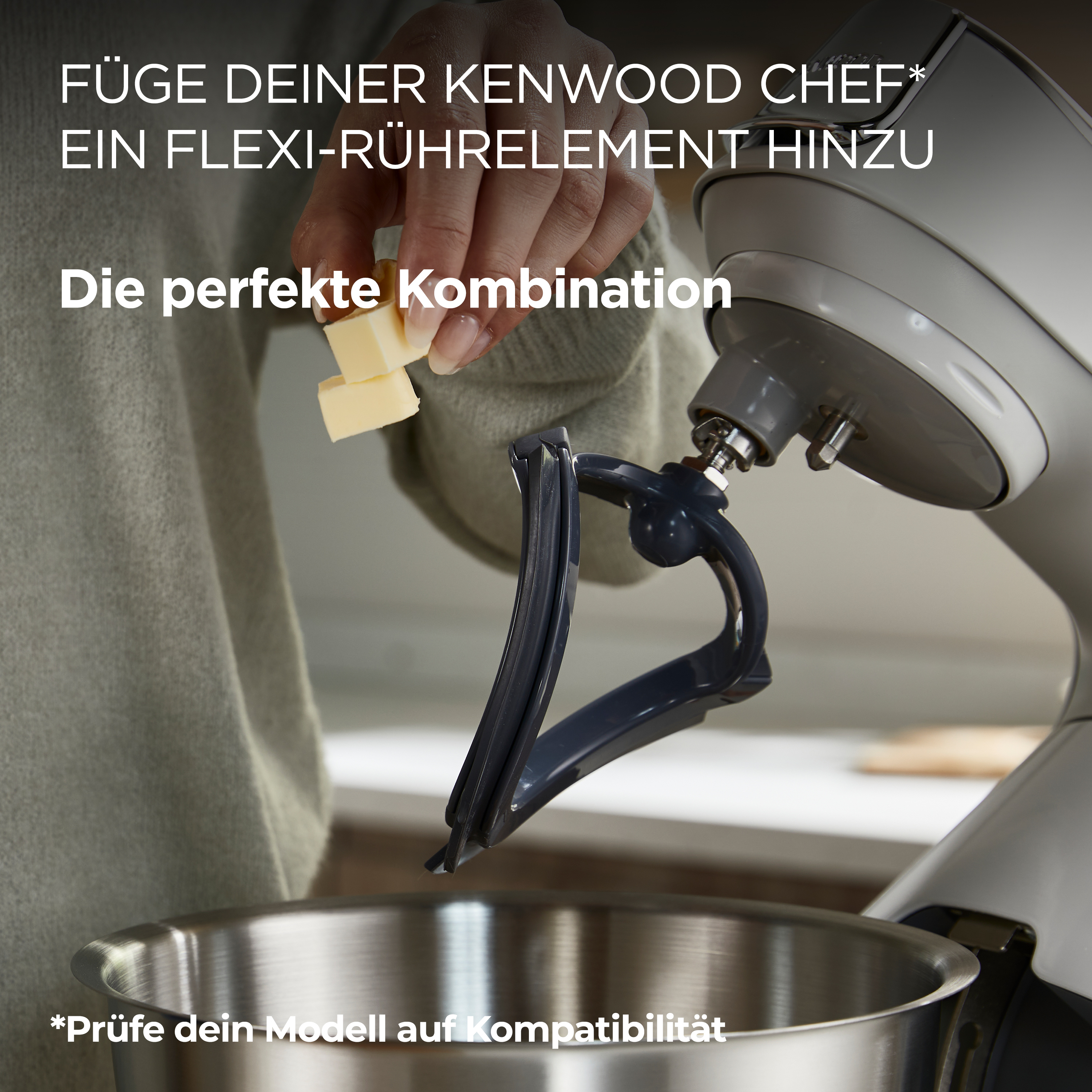 Eine Person gibt Butter in eine Rührschüssel mit einem Kenwood-Mixer. Es gibt einen Flexi-Schläger.