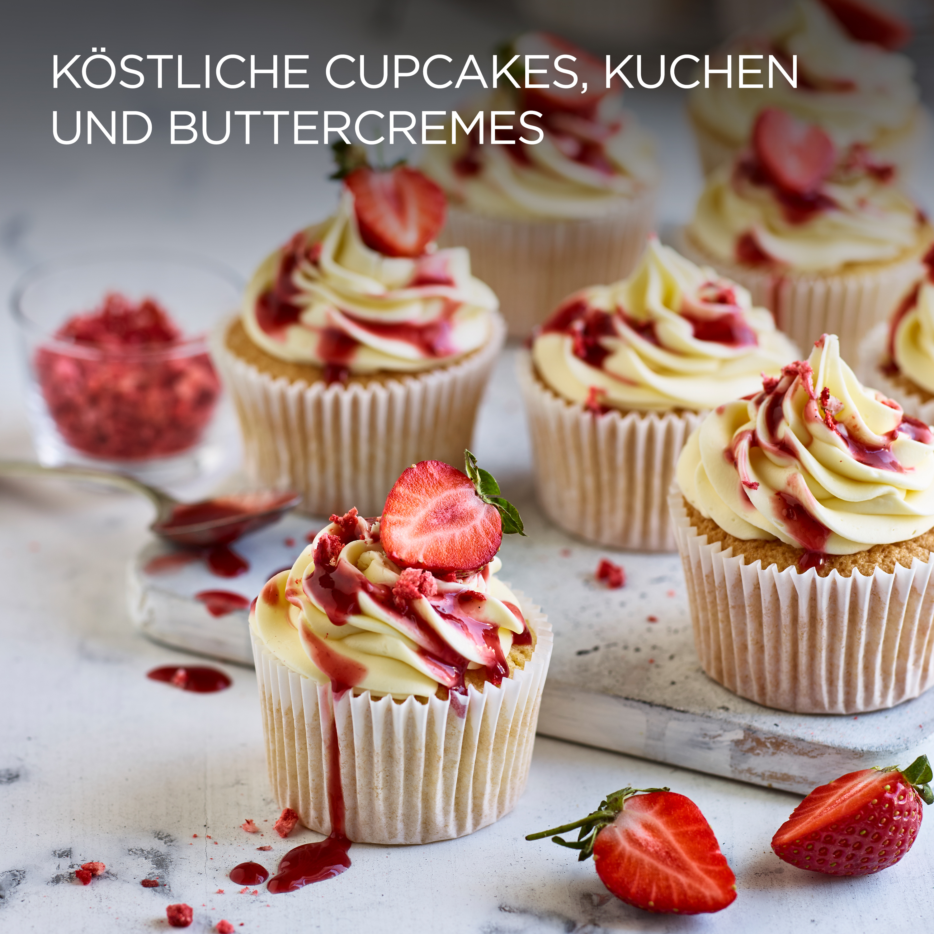 Cupcakes mit Sahne und Erdbeeren. Weiße Oberfläche und Hintergrund.