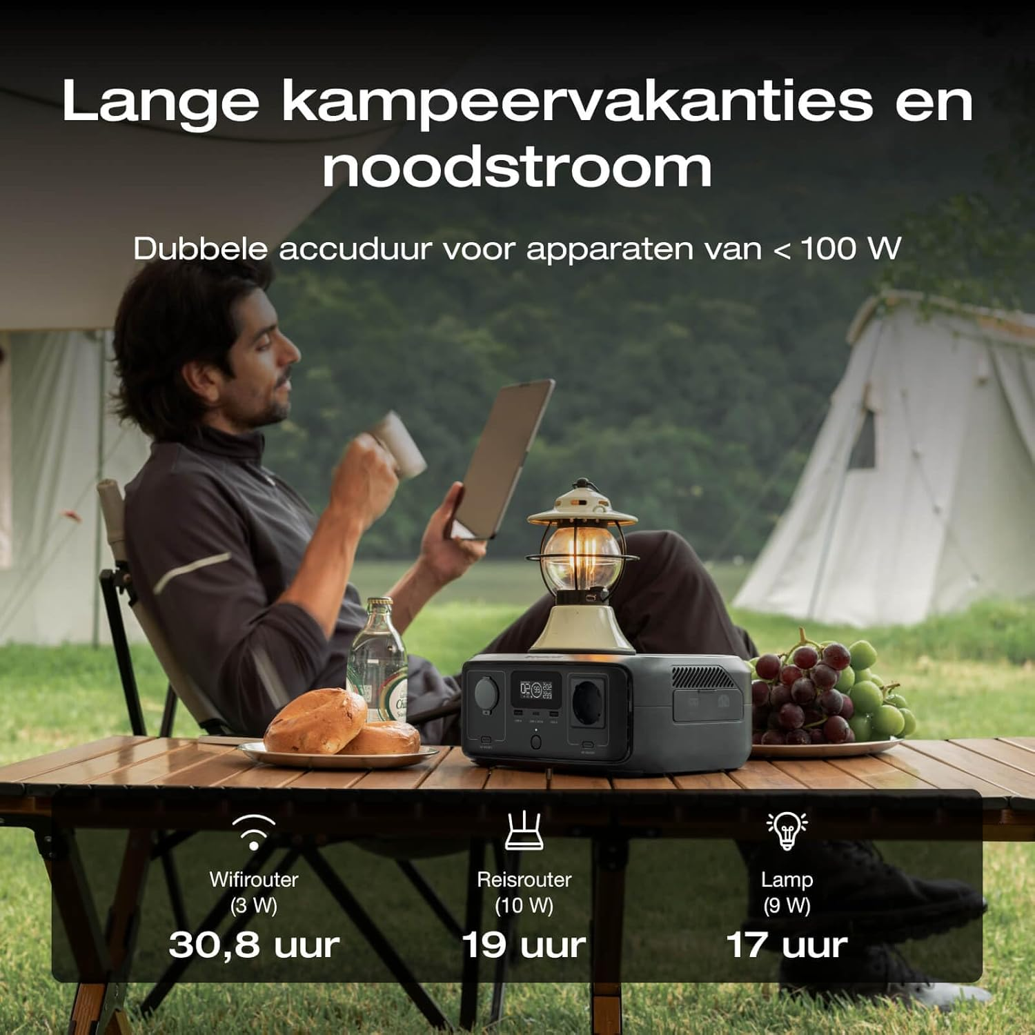 Man zit aan tafel, met een tent op de achtergrond. Energiecentrale.