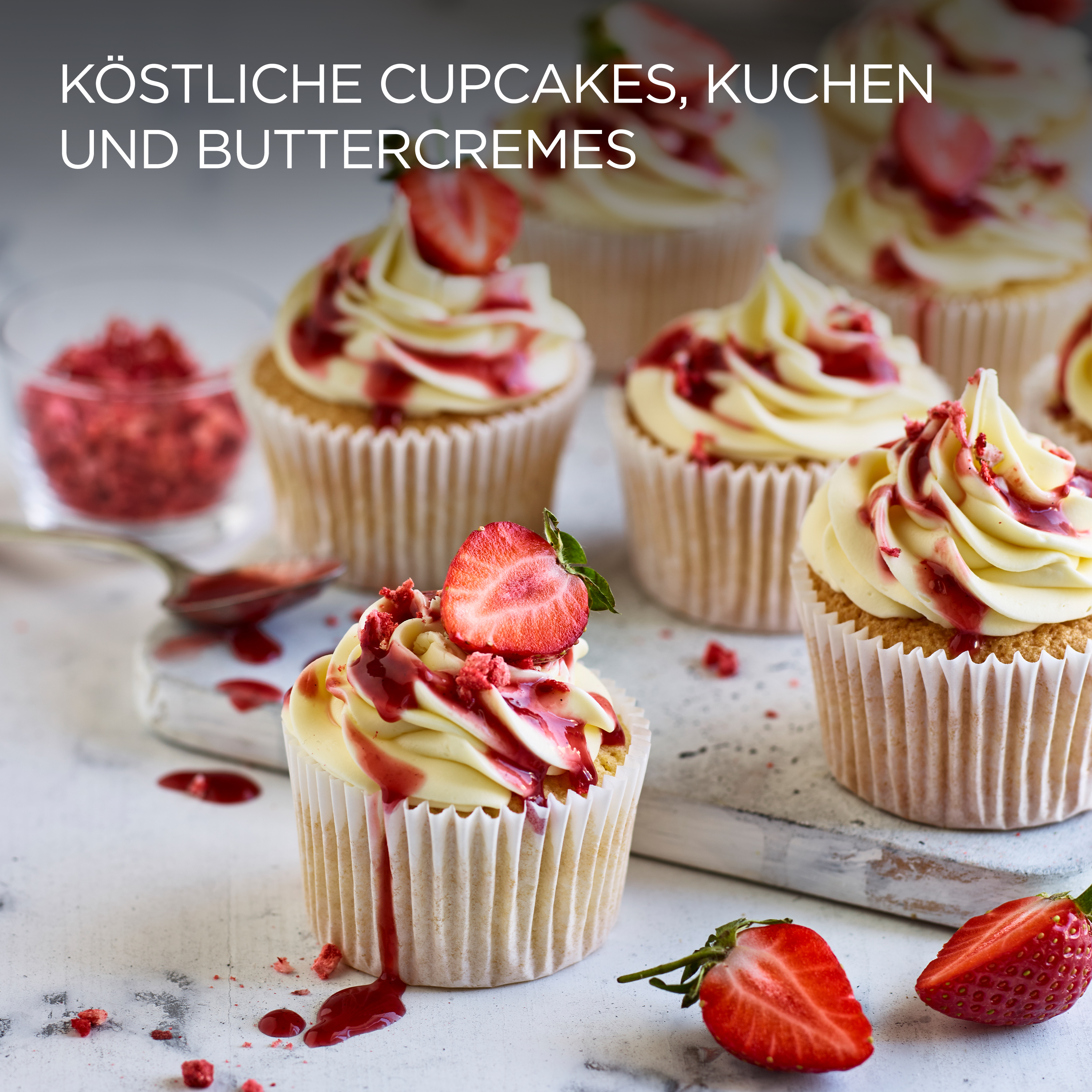Cupcakes mit weißem Frosting und Erdbeeren obenauf, mit weißem Hintergrund.