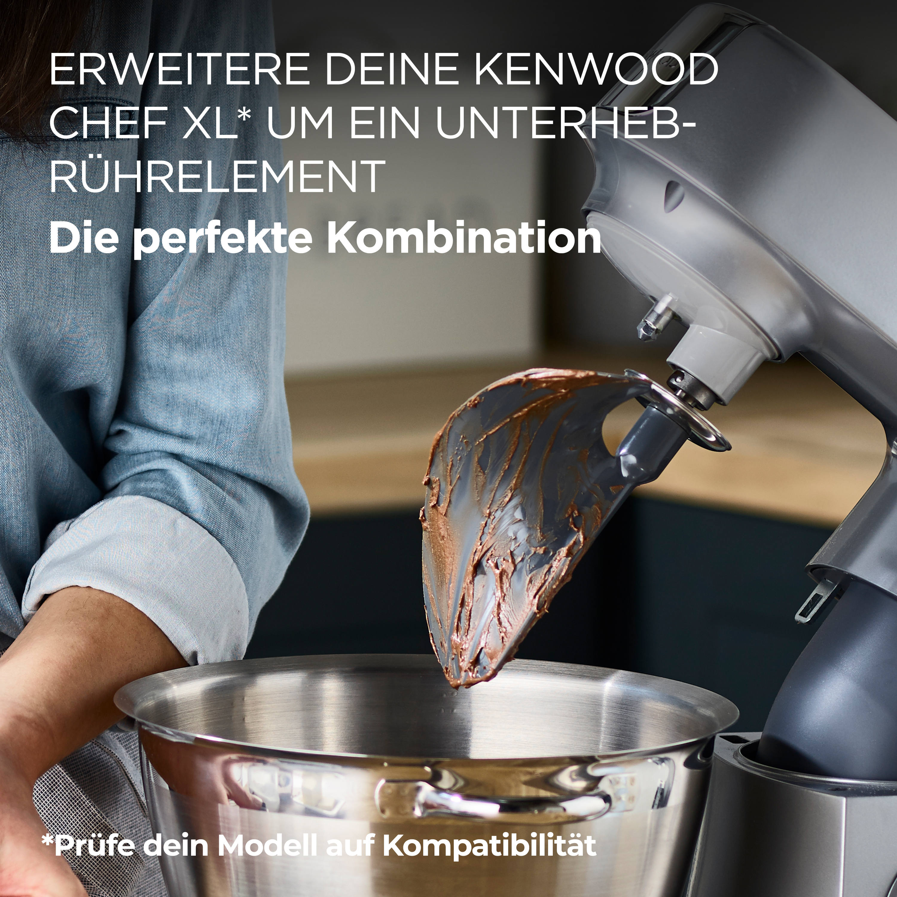 Person fügt einer silbernen Kenwood Chef XL Mixer-Schüssel Schokoladenmischung hinzu.