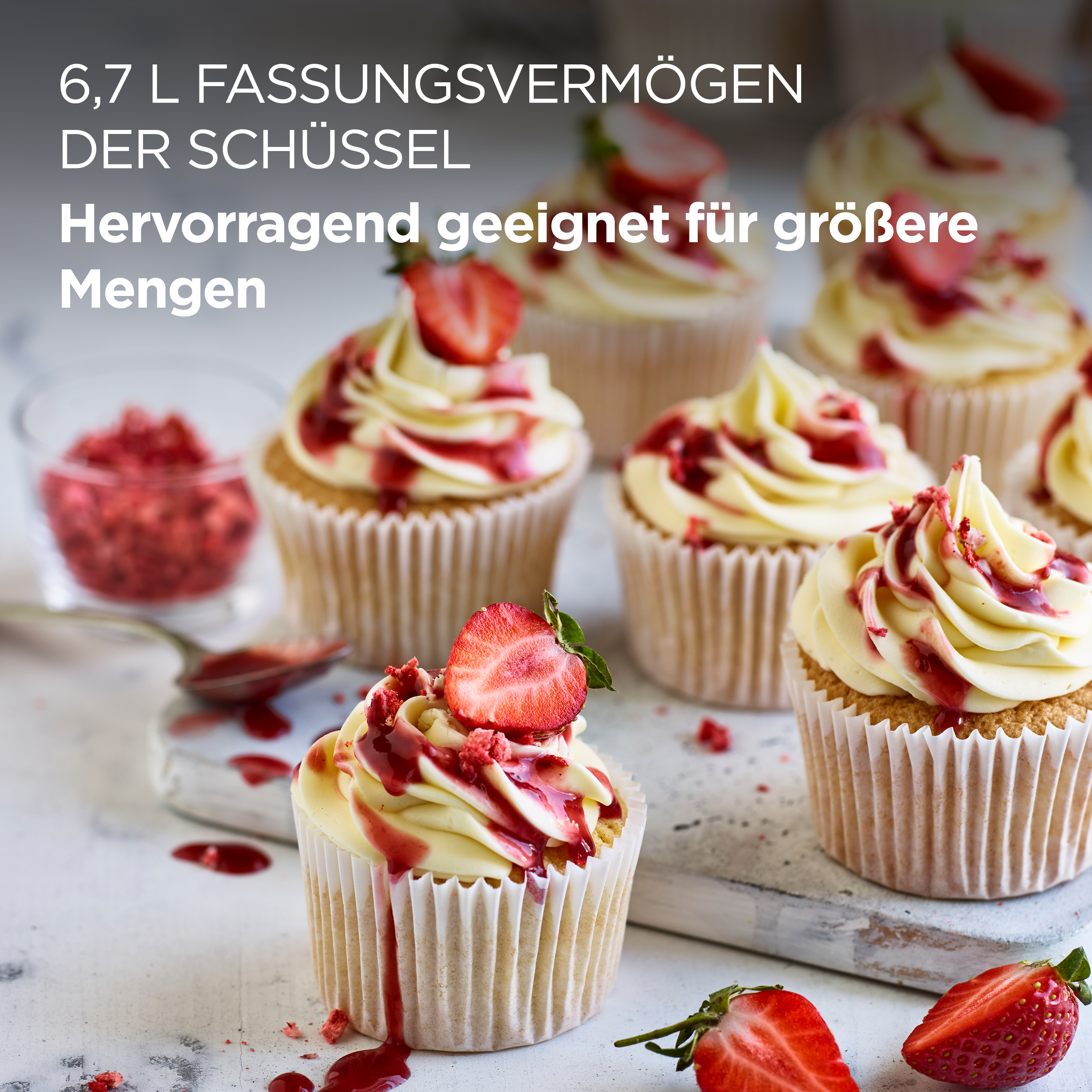 Cupcakes mit Zuckerguss und Erdbeeren. Einige haben roten Erdbeersauce-Guss oben drauf.