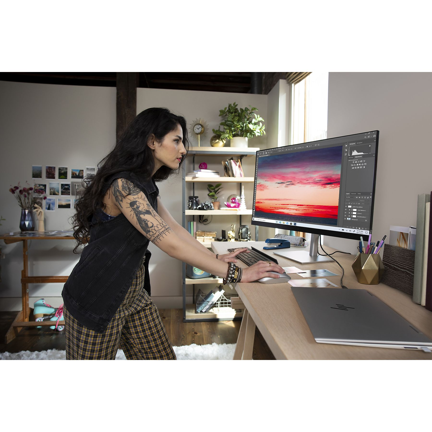Vrouw die op een bureau met een computer werkt. Bureau met laptop, monitor en kantoorbenodigdheden.