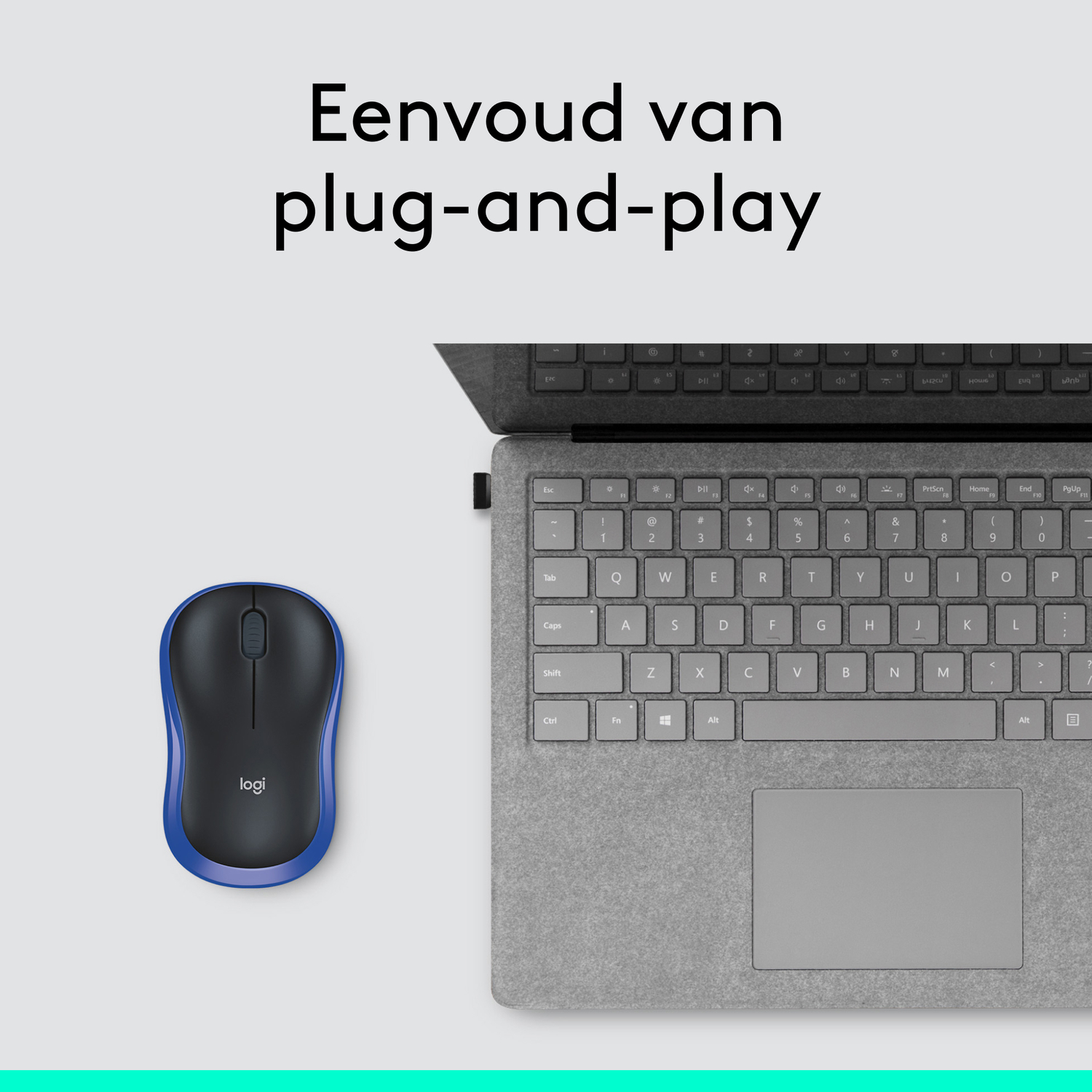 A black mouse with blue accents next to a laptop keyboard.