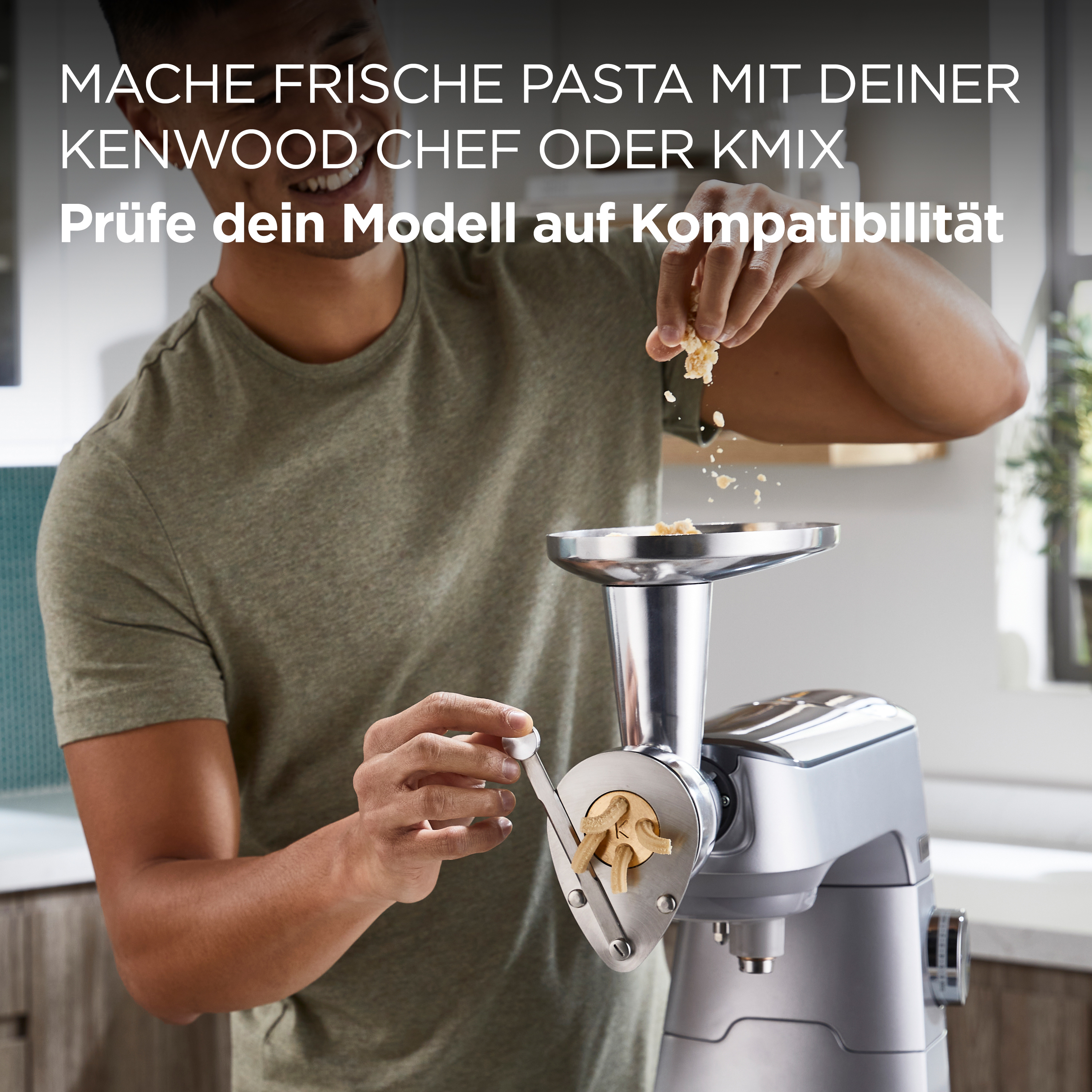 Mann in grünem Hemd benutzt Kenwood-Nudelmacher und gibt Nudeln in die Maschine.