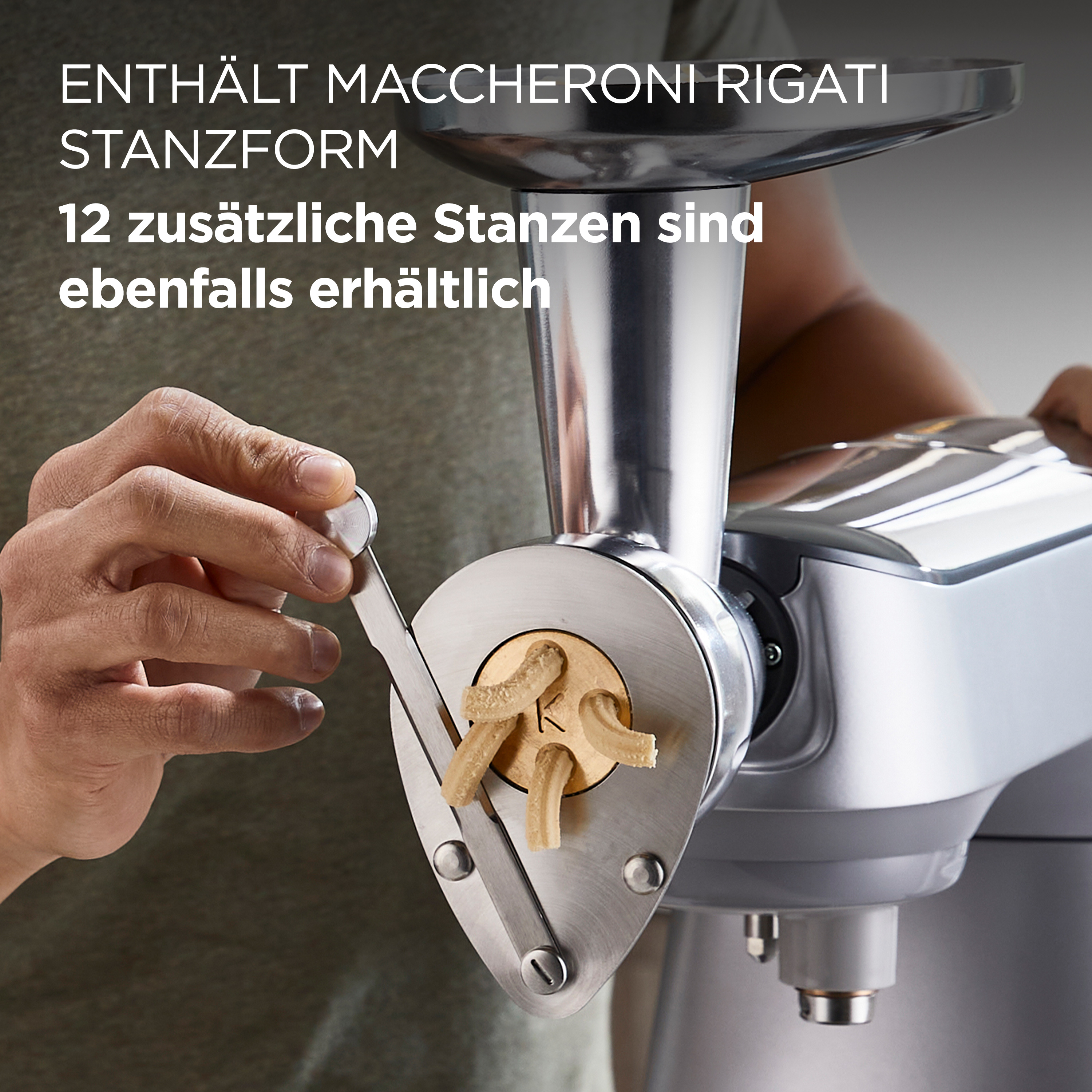 Eine Hand benutzt eine Pastamaschine. Nudeln kommen aus der Maschine.