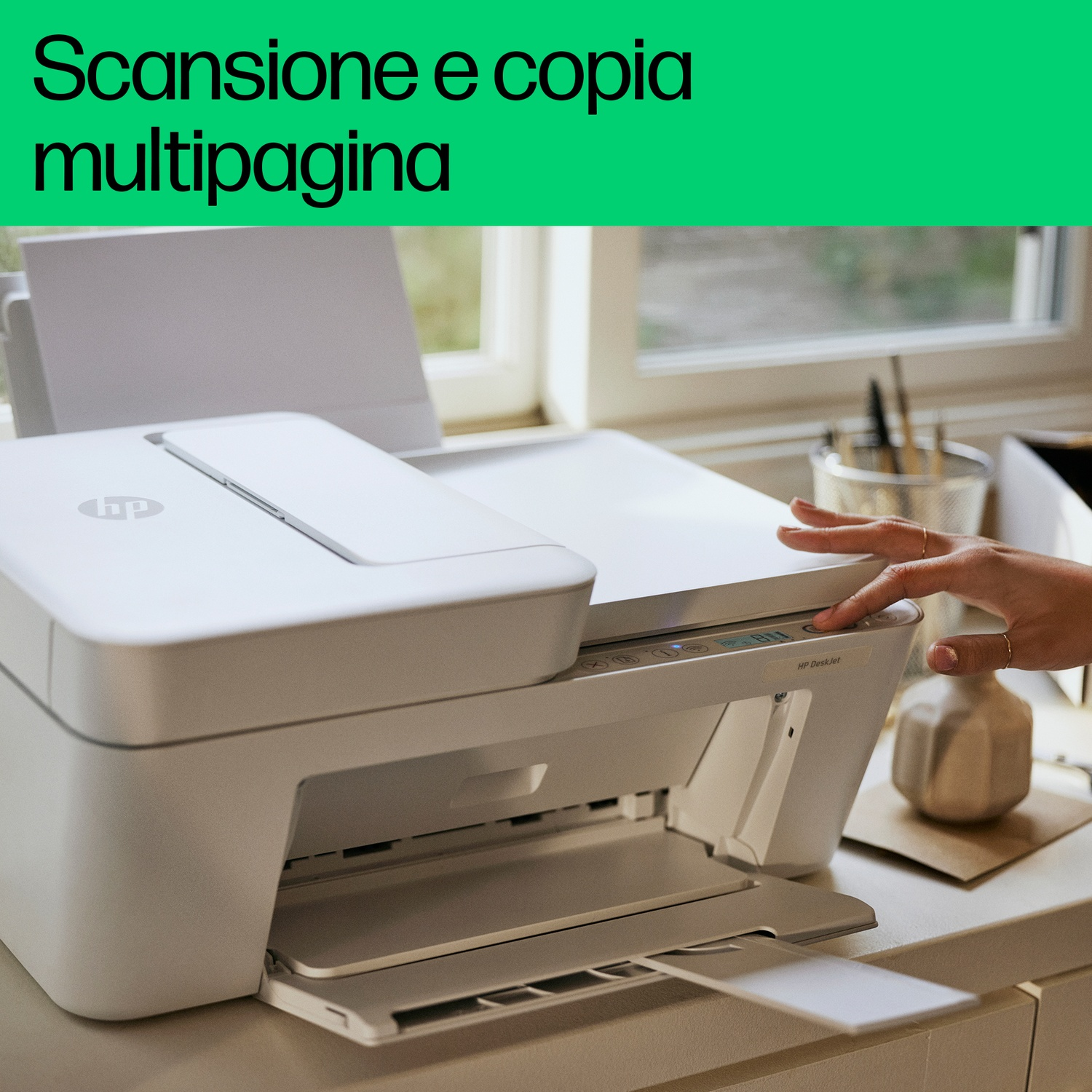 Stampante bianca con una mano che preme un pulsante. Il testo dice 'Scansione e copia multipagina'.