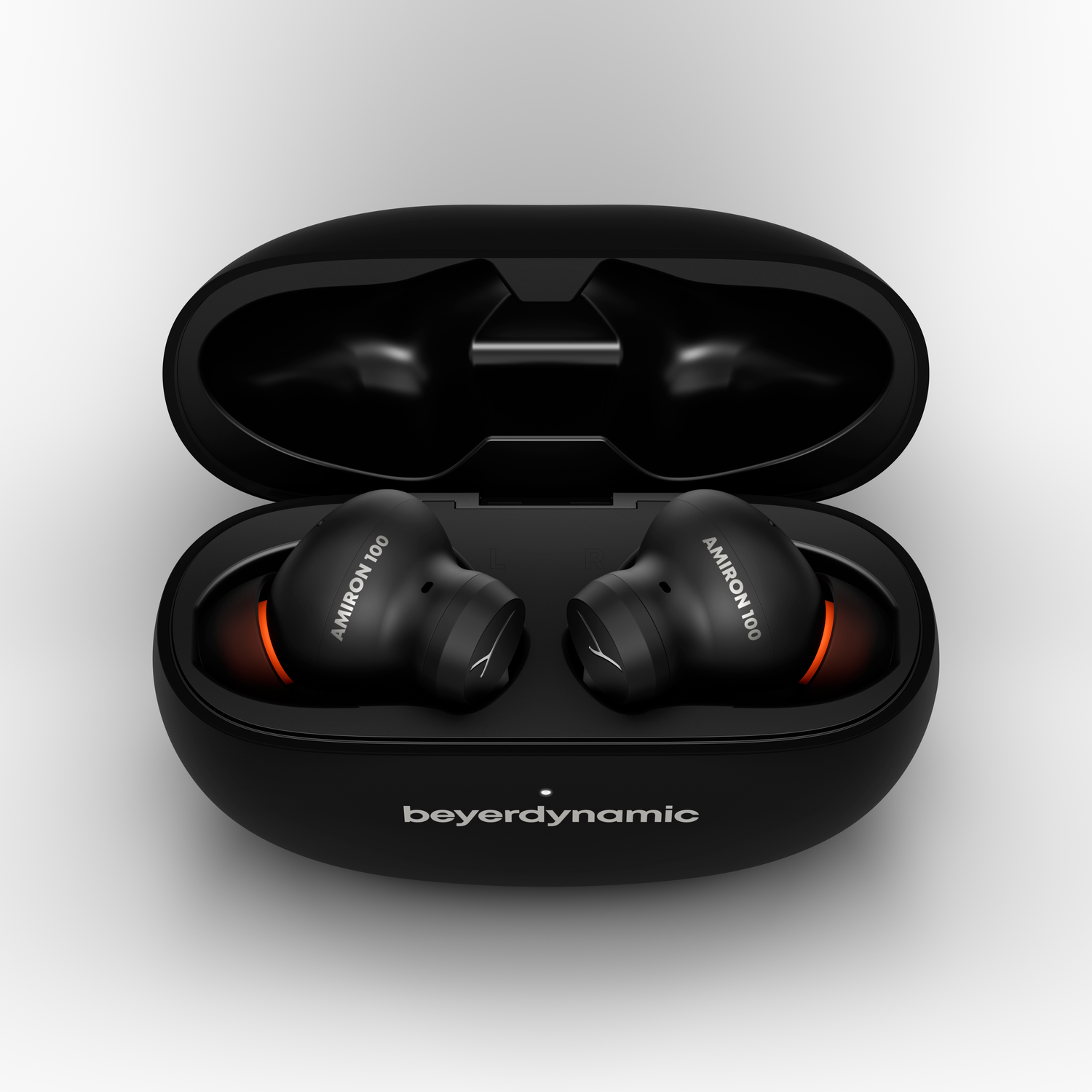Black earbuds with orange accents in an open charging case. Beyerdynamic logo.
