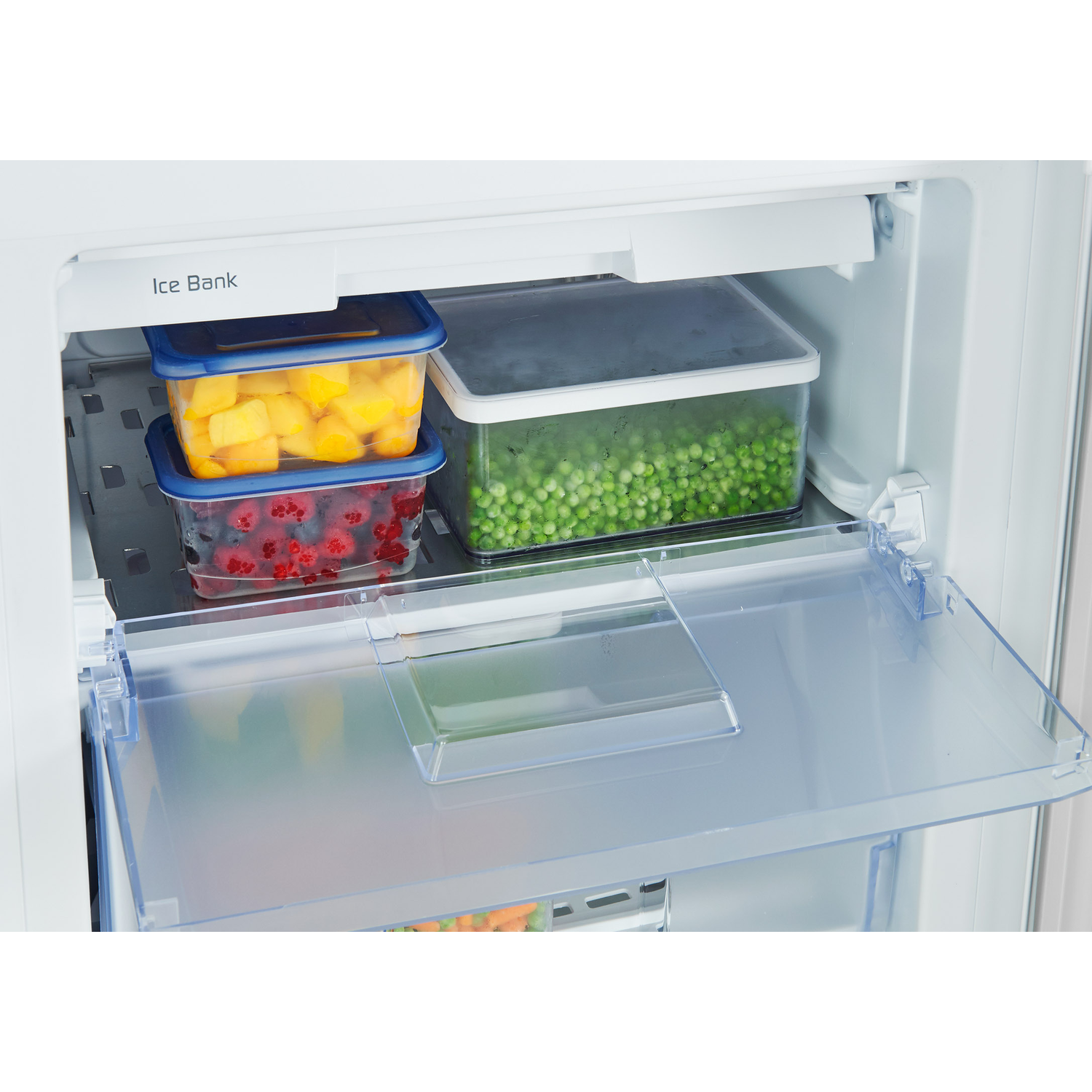 Refrigerator interior: fruit in containers, peas, and a shelf.