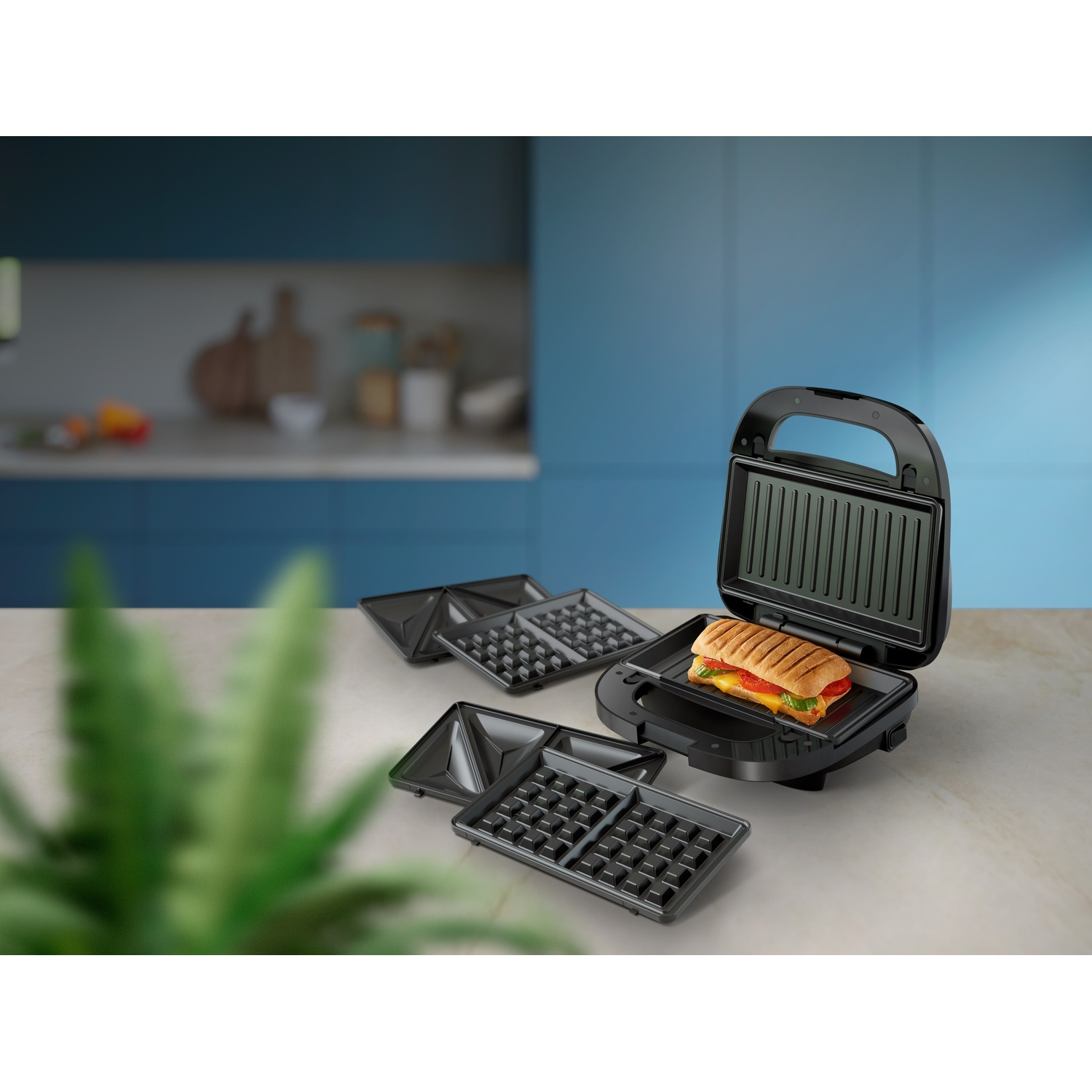 Una macchina per sandwich con un sandwich all'interno e piastre per waffle, su un piano cucina.
