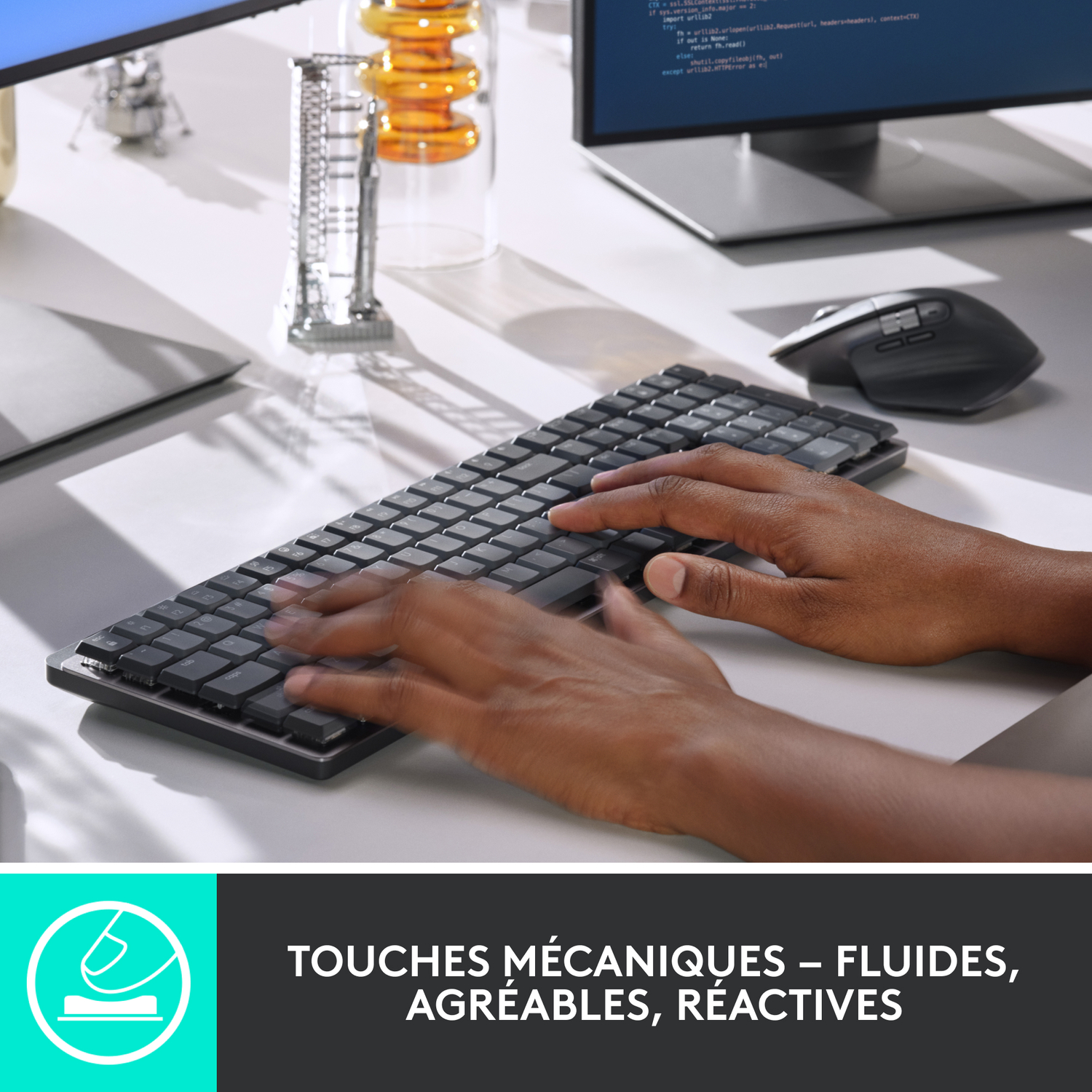 Personne tapant sur un clavier noir, avec un ordinateur et une souris à proximité.