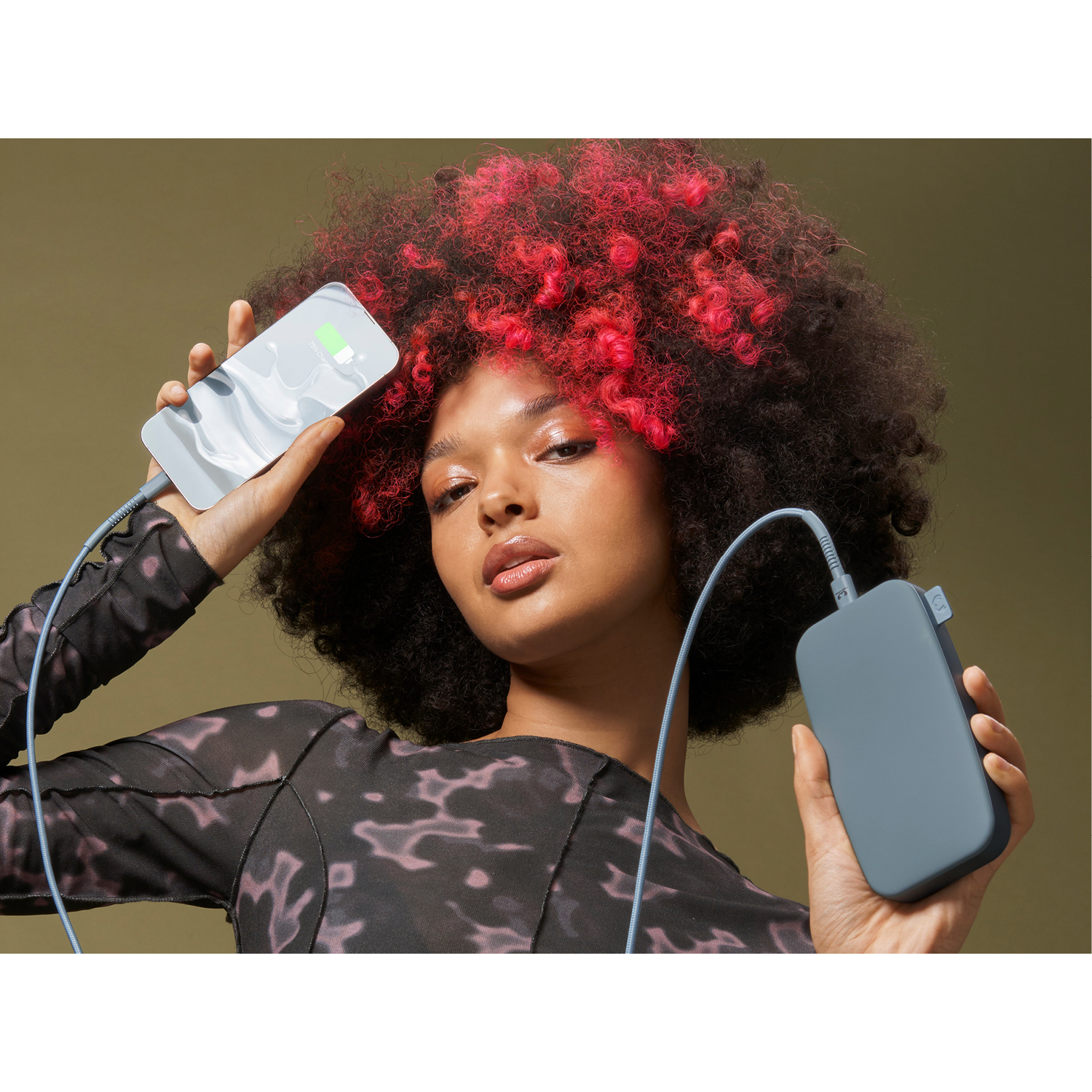Deux batteries externes, bleues et noires, avec une femme tenant un téléphone en charge.