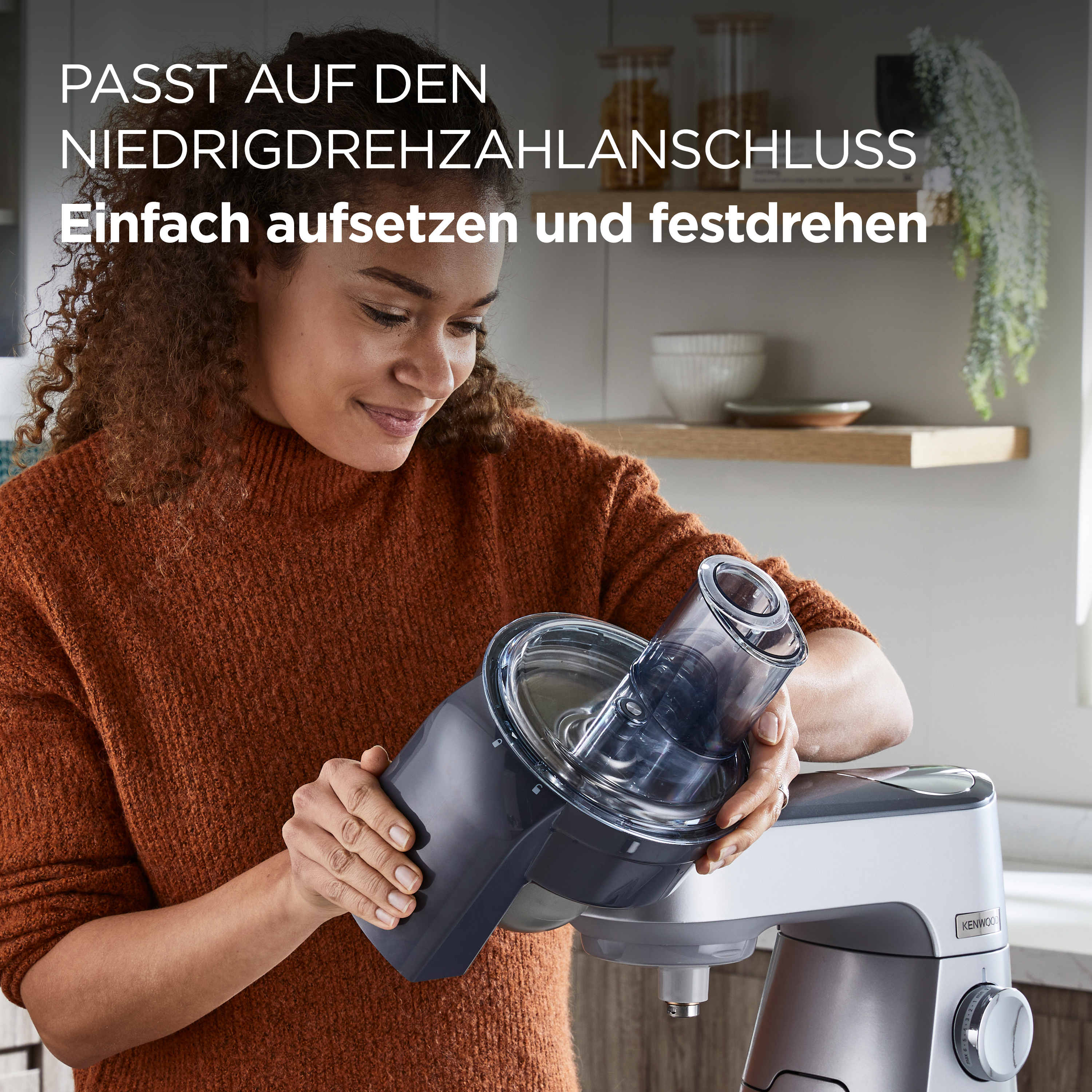 Frau befestigt einen Küchenmaschinenaufsatz. Text auf Deutsch.
