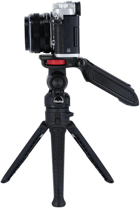 Fotocamera su un piccolo treppiede. Fotocamera nera e argento con treppiede nero.