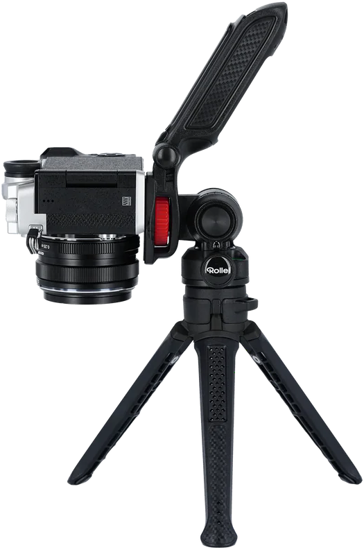 Fotocamera nera su un treppiede nero, con una manopola di regolazione rossa, sfondo nero.