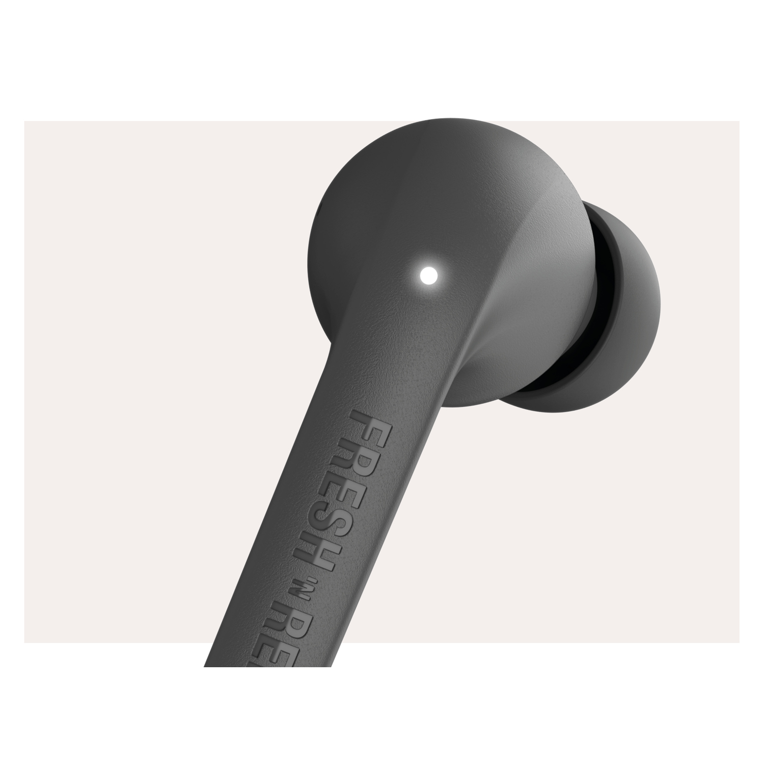 A close-up of a black earbud with the text FRESH 'N REBEL on it.