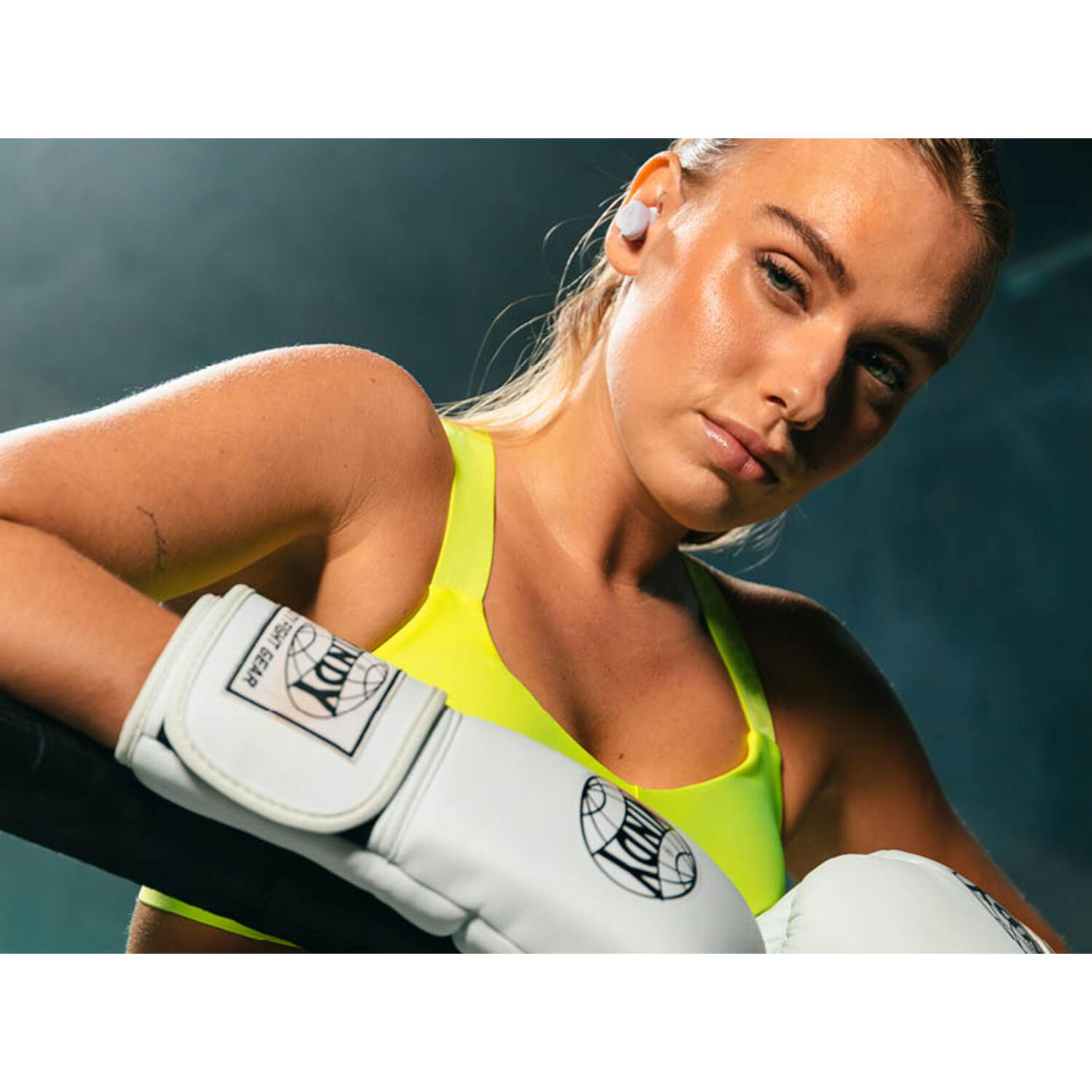 Femme blonde avec gants de boxe et soutien-gorge de sport.