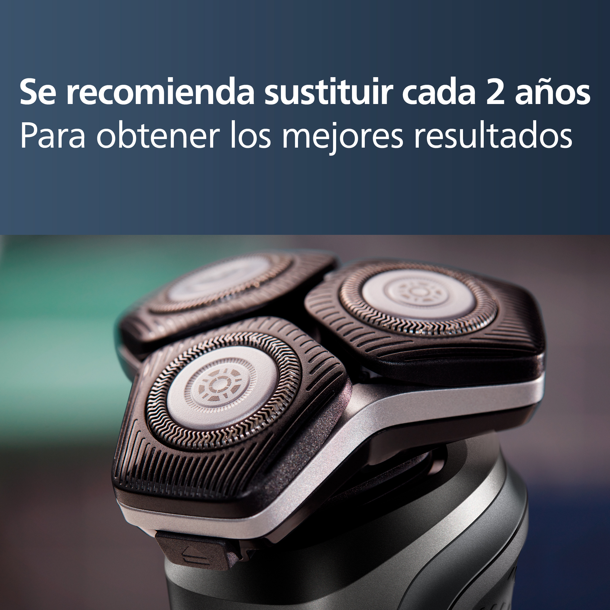 Primer plano de cabezales de afeitadora. Tres cuchillas circulares sobre base gris y negra.