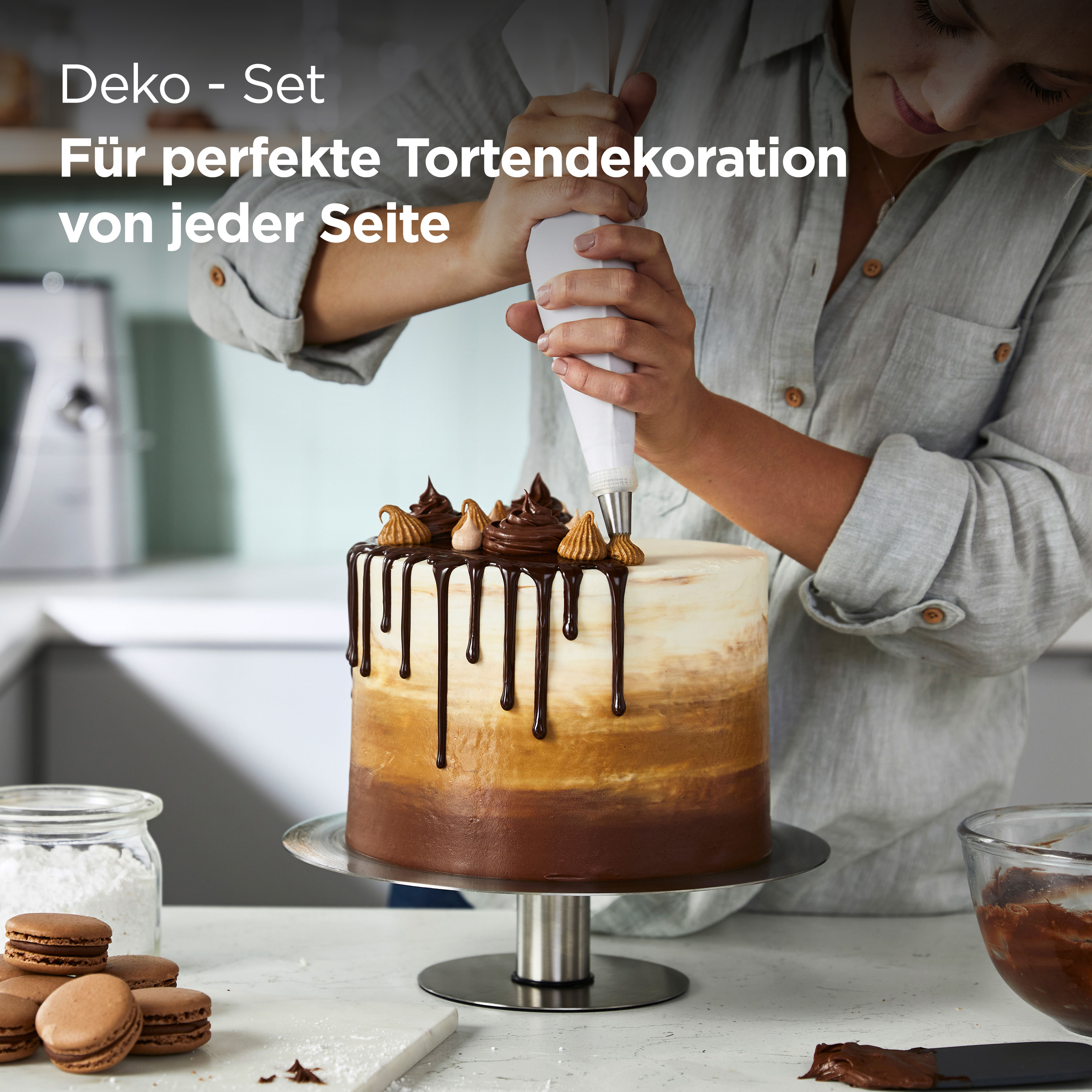 Eine Frau dekoriert einen Kuchen mit Schokoladenfrosting aus einem Spritzbeutel. Es gibt Makronen.