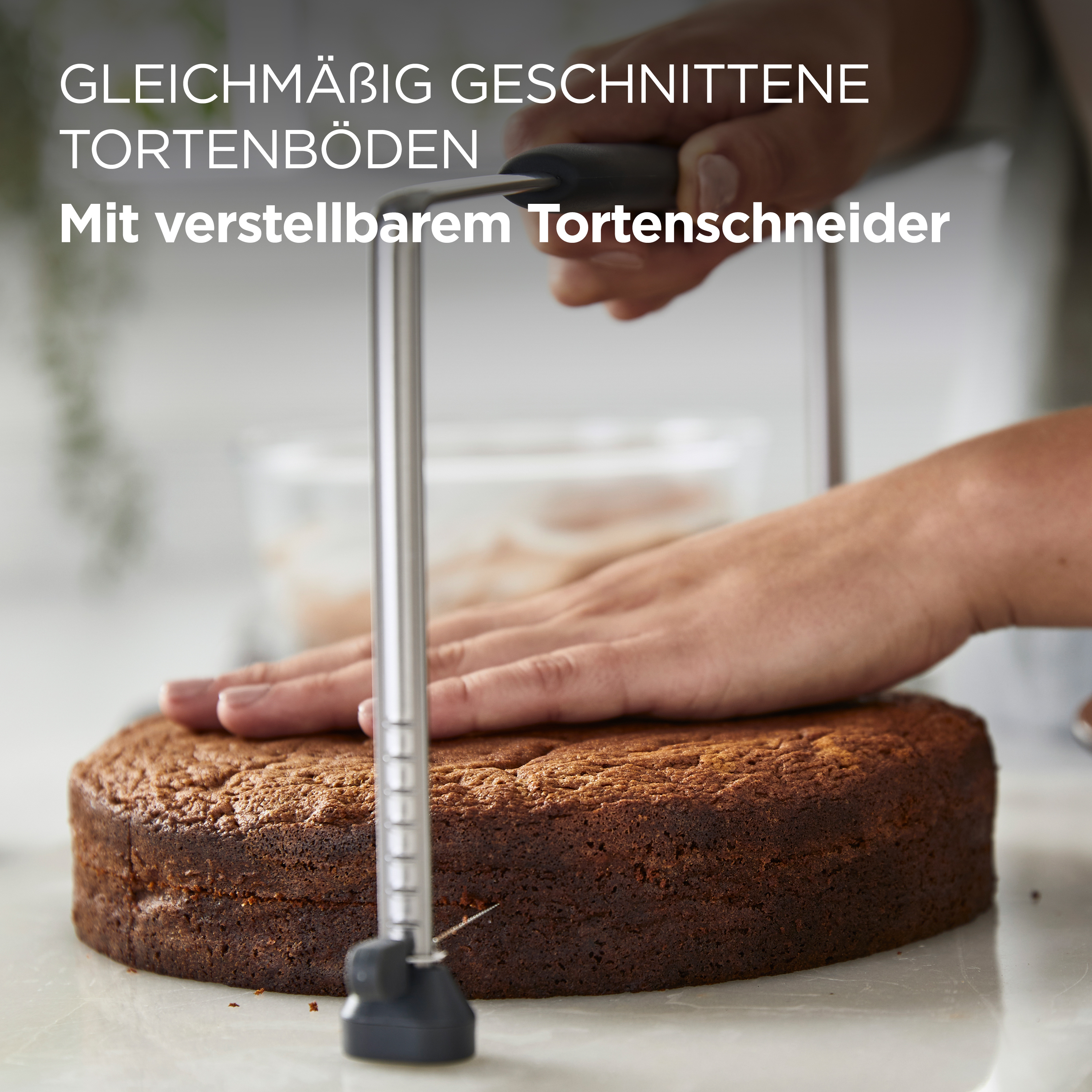 Eine Person schneidet einen Kuchen mit einem verstellbaren Tortenschneider.