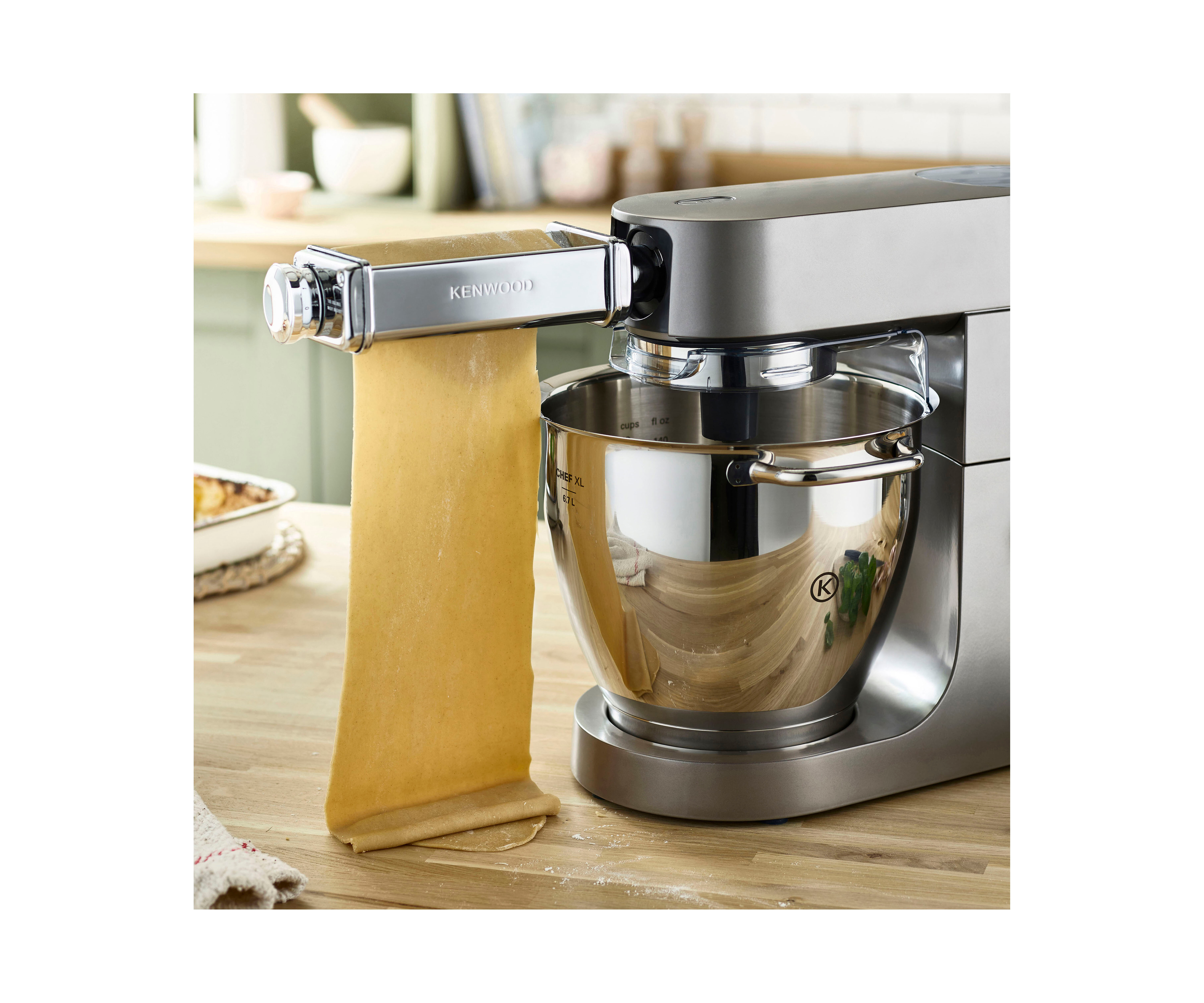 Silberner Kenwood-Mixer mit Nudelwalzenaufsatz, Nudeln hängen.