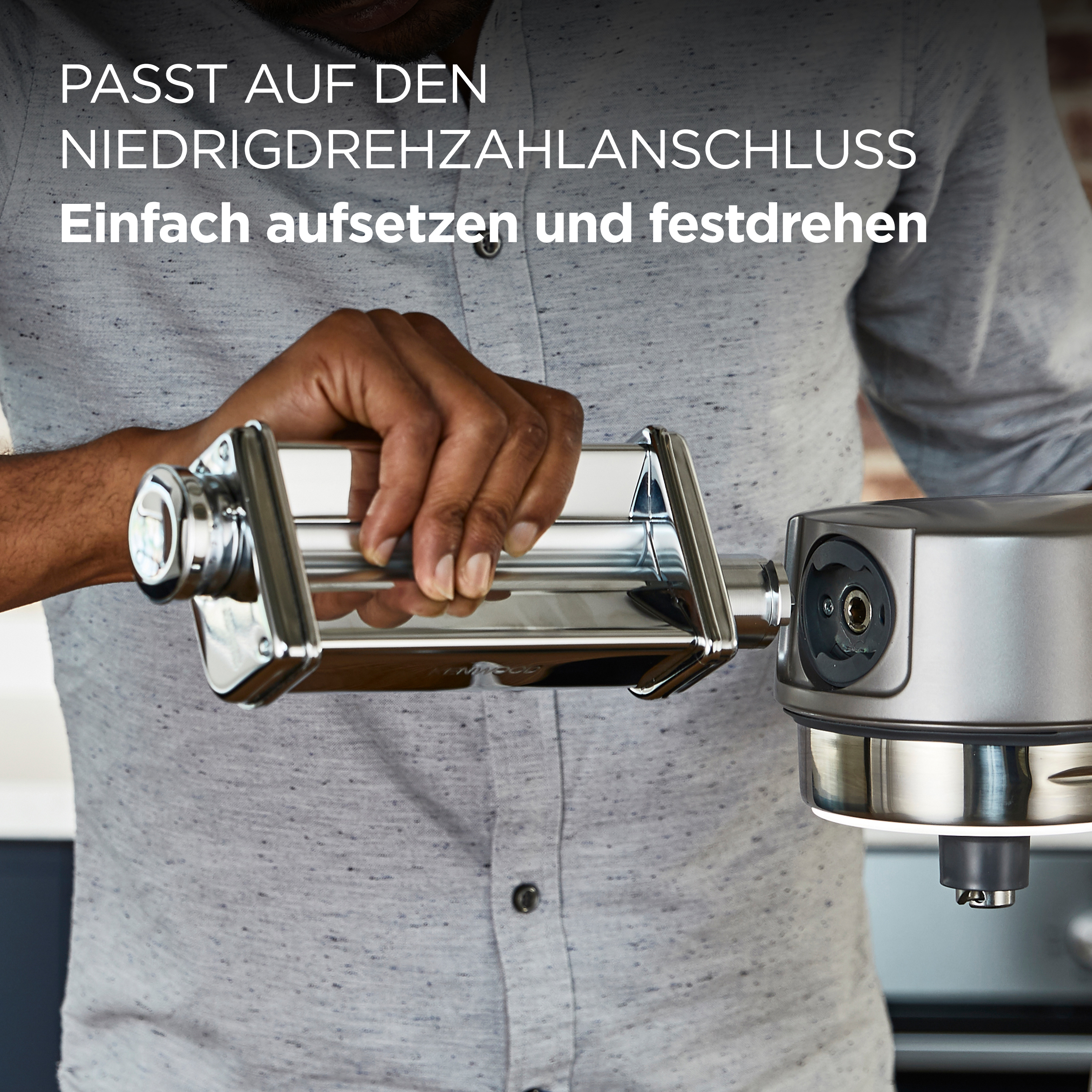 Eine Person befestigt einen Pastamaschinenaufsatz an einem silbernen Küchengerät. Text auf Deutsch.