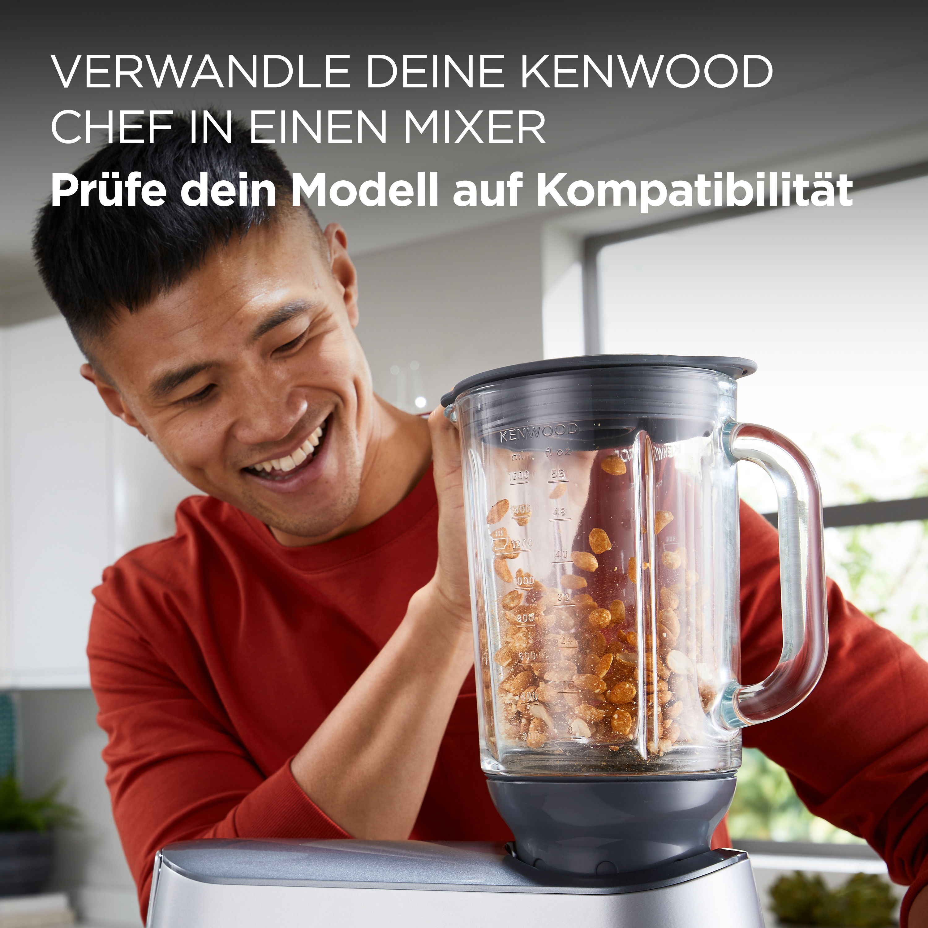 Mann lächelt und schaut auf einen Mixer mit Essen.