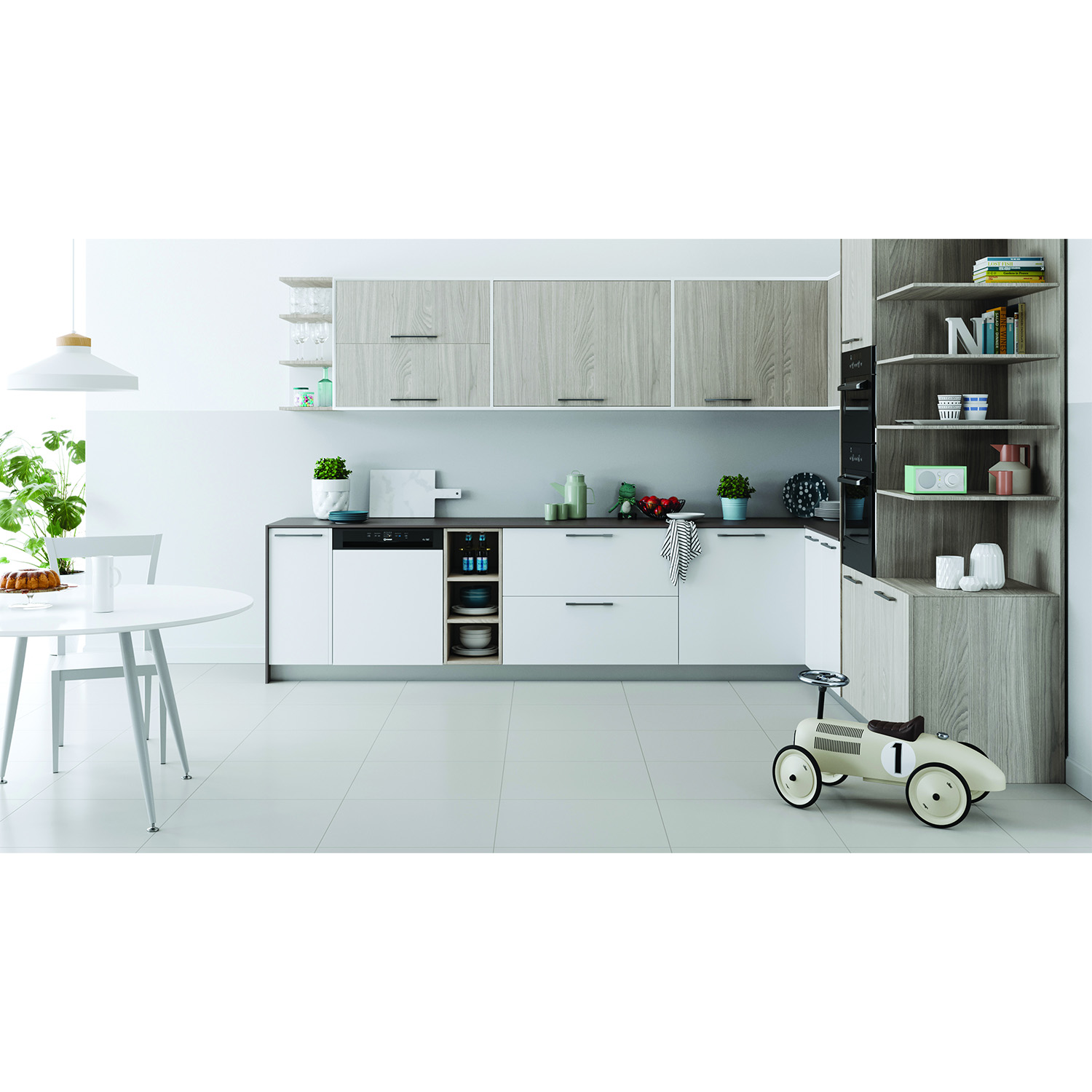Cucina con mobili bianchi, superiori in legno, elettrodomestici e tavolo bianco con torta.