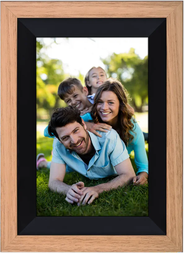 Portrait de famille dans un cadre en bois. Parents et enfants souriant sur l'herbe.