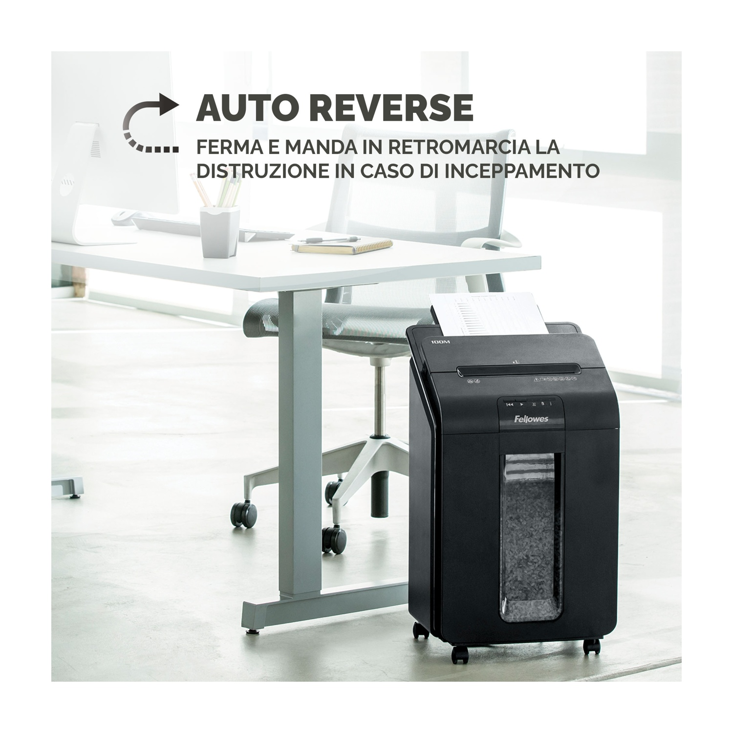 Distruggidocumenti nero in un ambiente ufficio. Testo: 'Auto Reverse'. Sfondo ufficio.