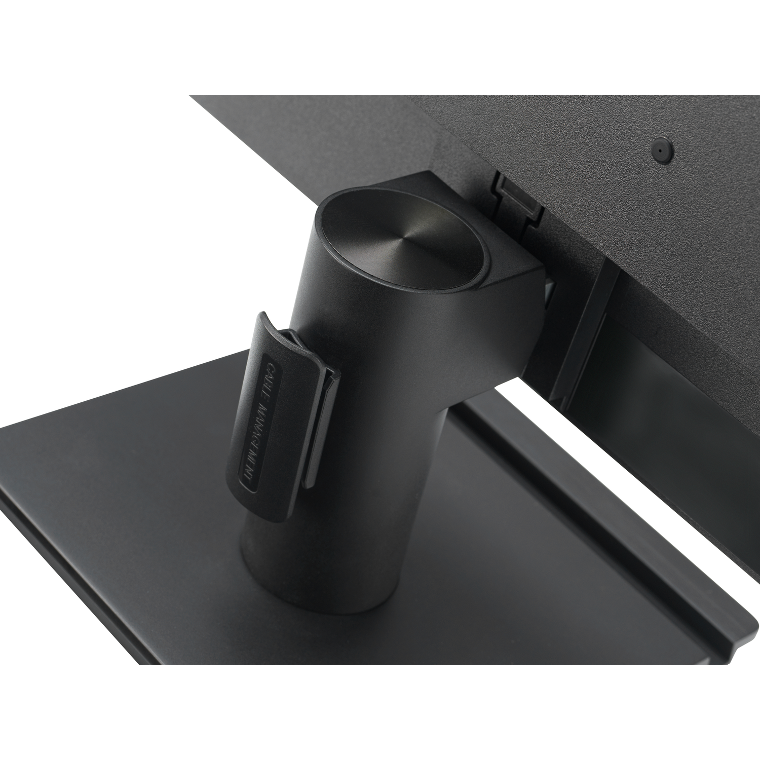 Zwarte monitorvoet, close-up met een kabelbeheerclip.