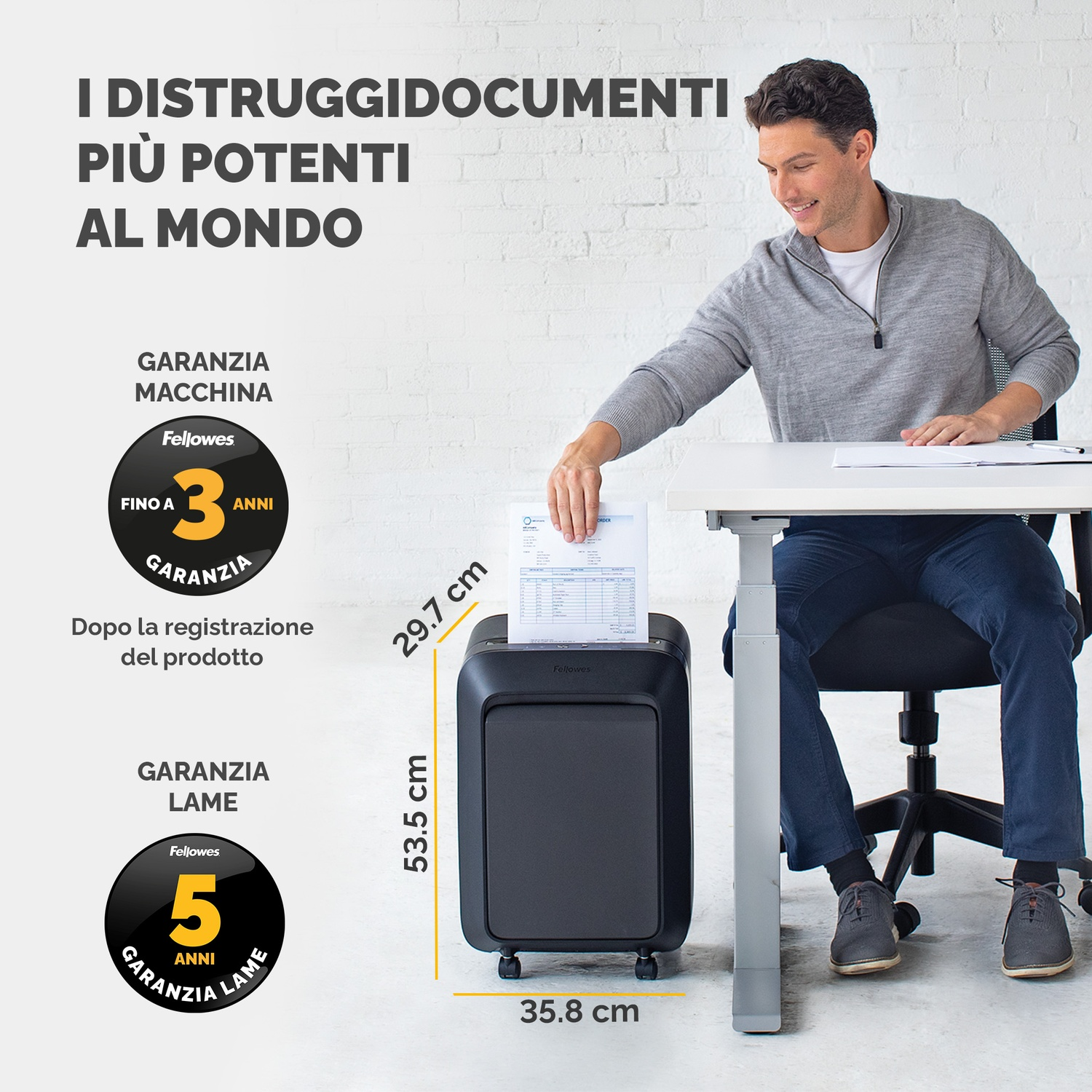 Un uomo che mette un foglio in un tritacarta nero su una scrivania bianca.