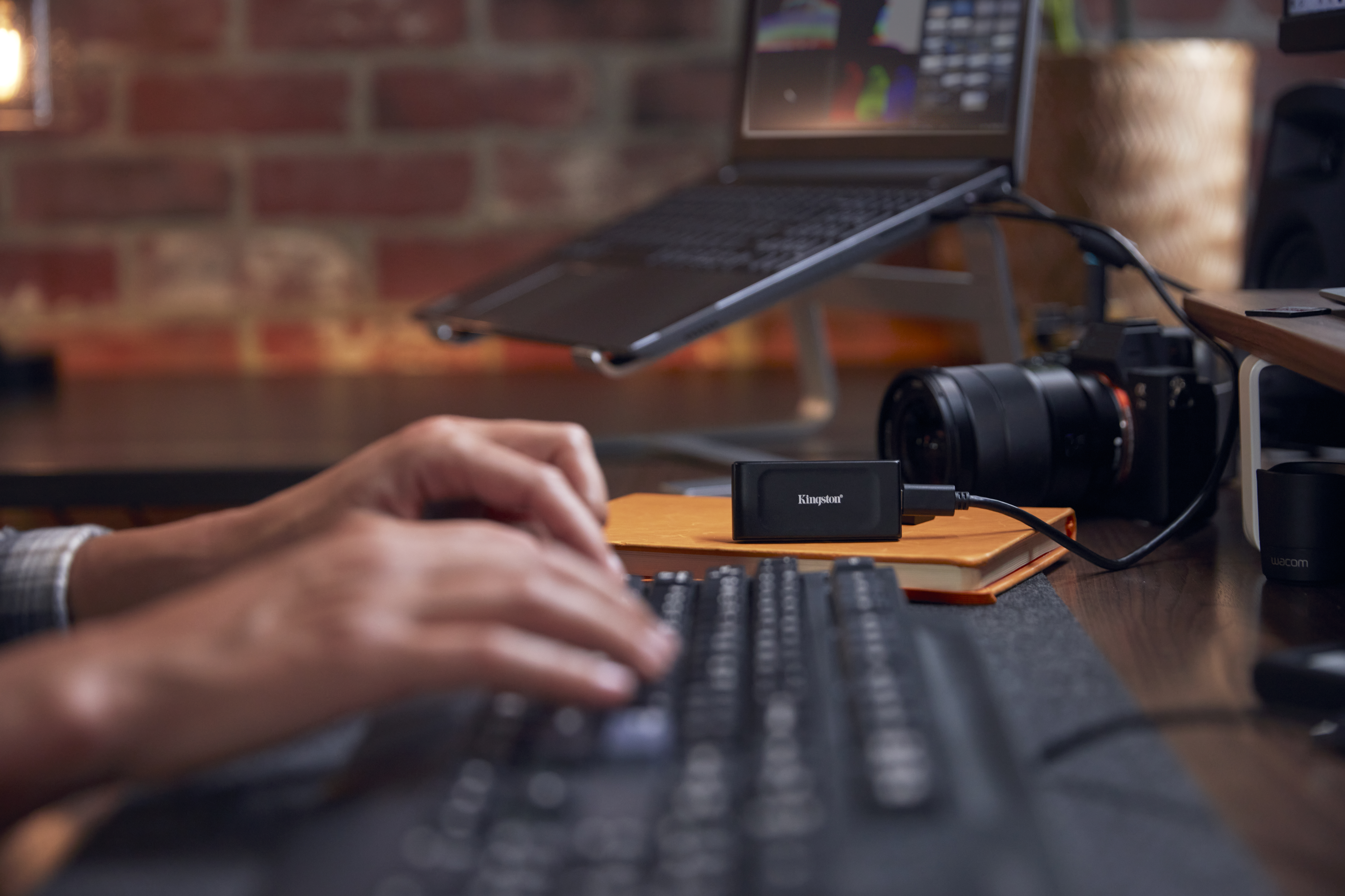 Person tippt auf Tastatur, neben Laptop und Kingston Kartenleser.