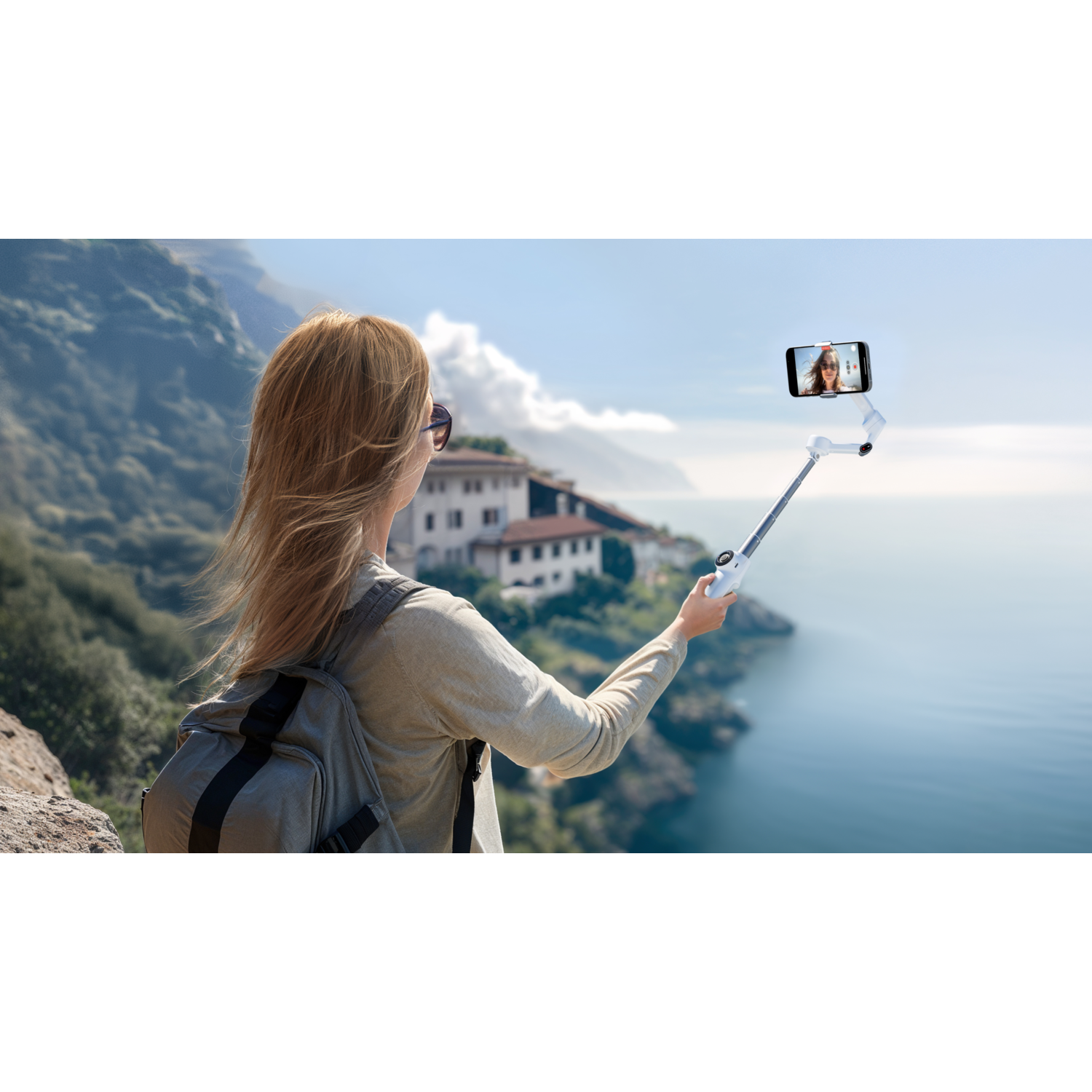 Woman taking selfie with selfie stick, scenic background.