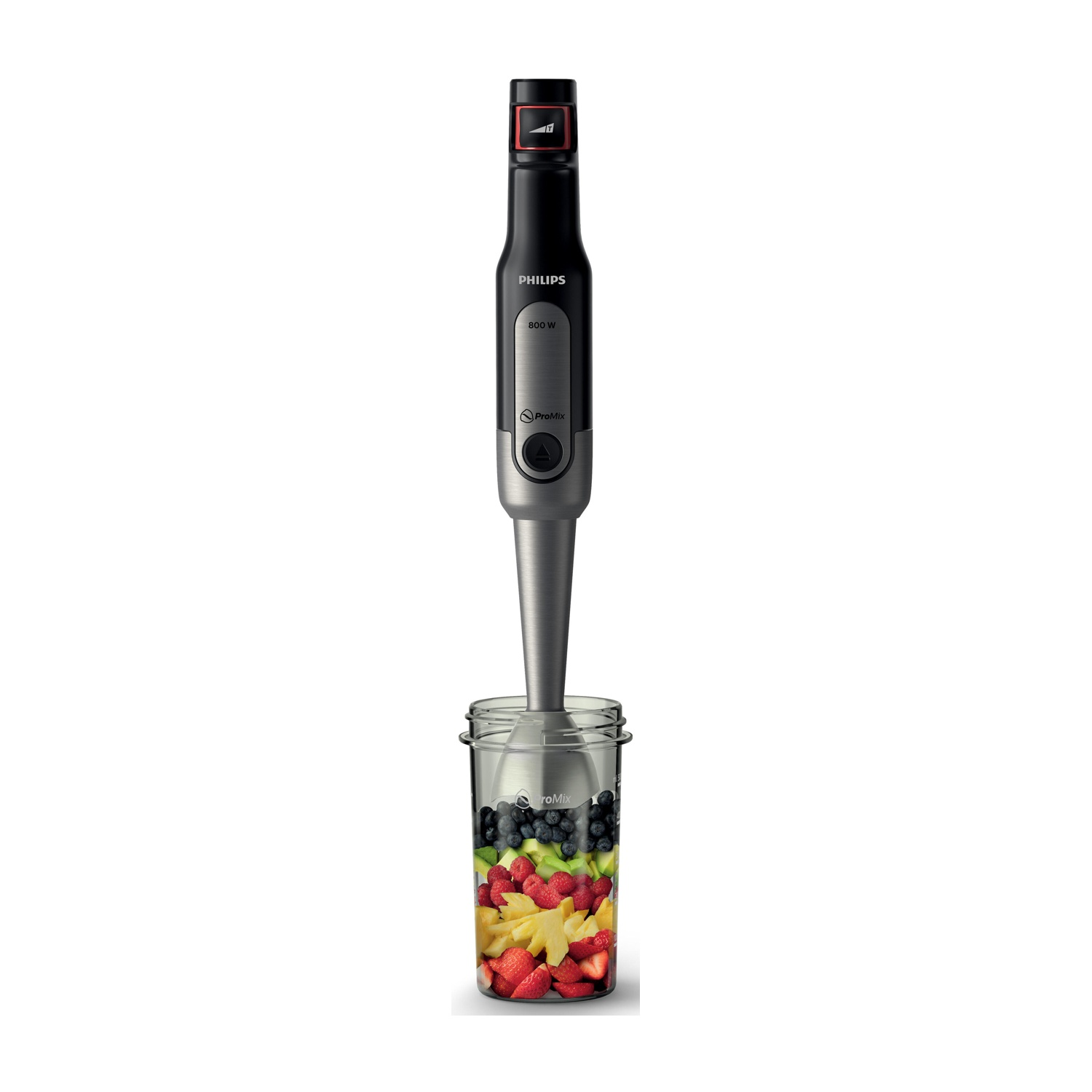 Frullatore a immersione Philips in un bicchiere con frutta mista. Colori nero e argento.  