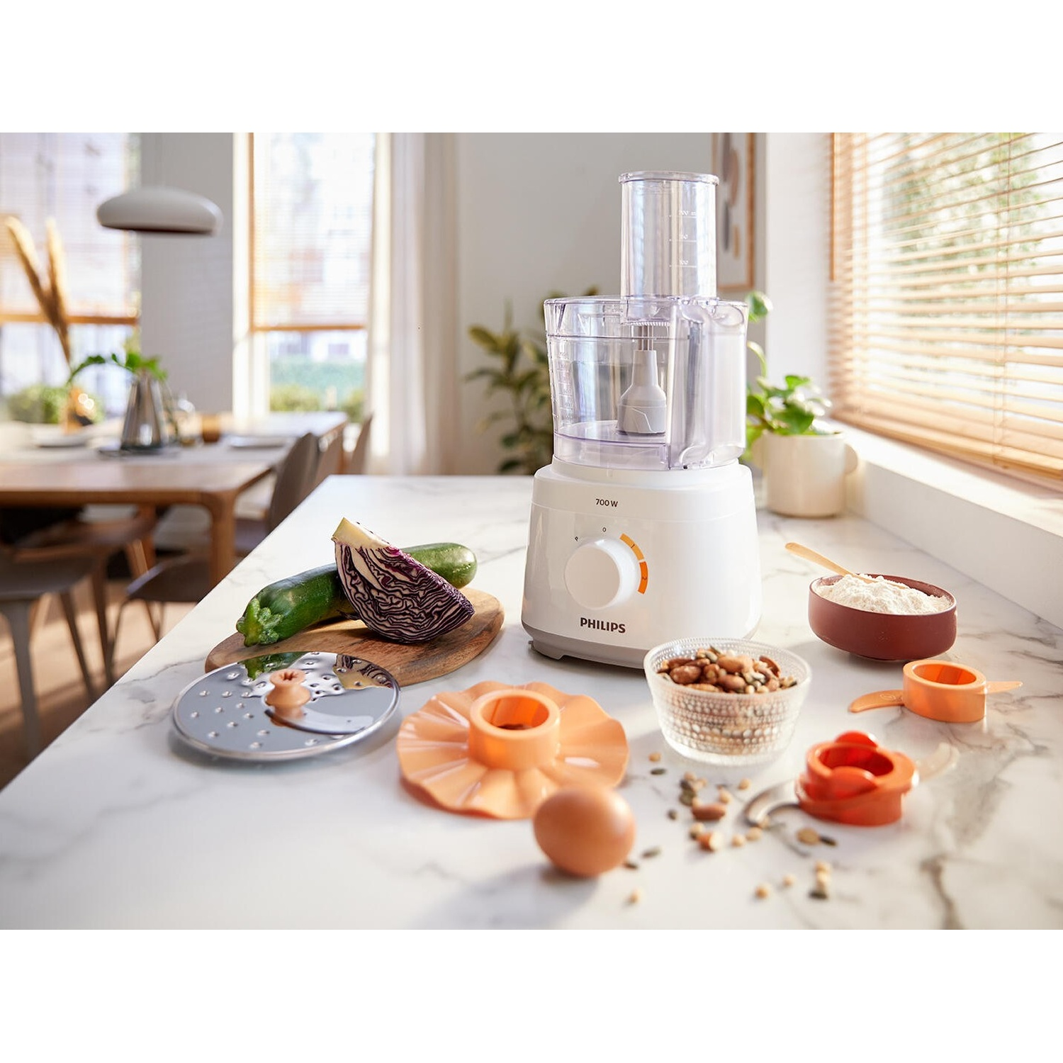 Robot da cucina con ingredienti: zucchine, cavolo rosso, noci, uovo e utensili.