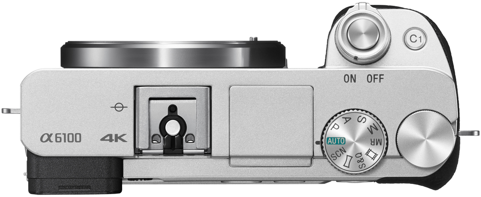 Fotocamera argentata, vista dall'alto, con pulsanti, ghiere e obiettivo. Interruttore On/Off visibile.