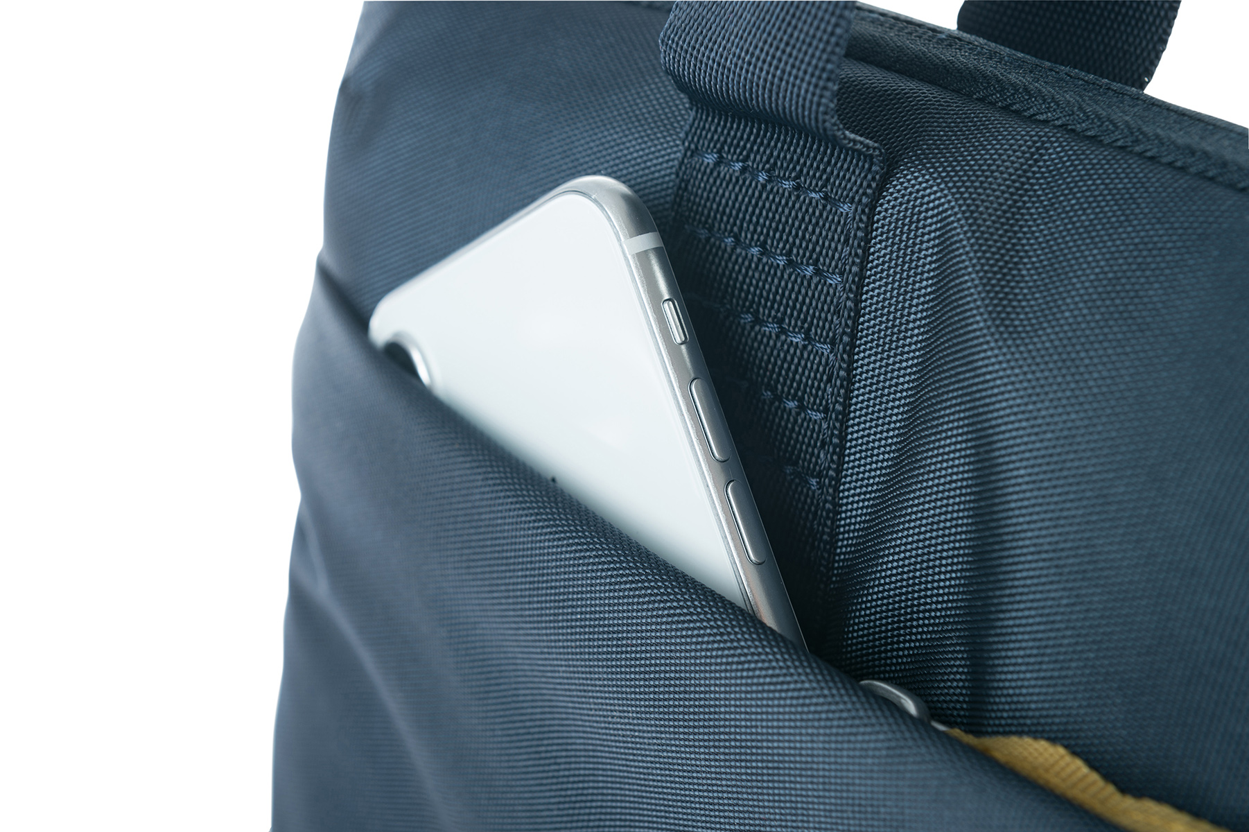Bir telefon, lacivert bir çantanın cebinde kısmen görünür durumda.