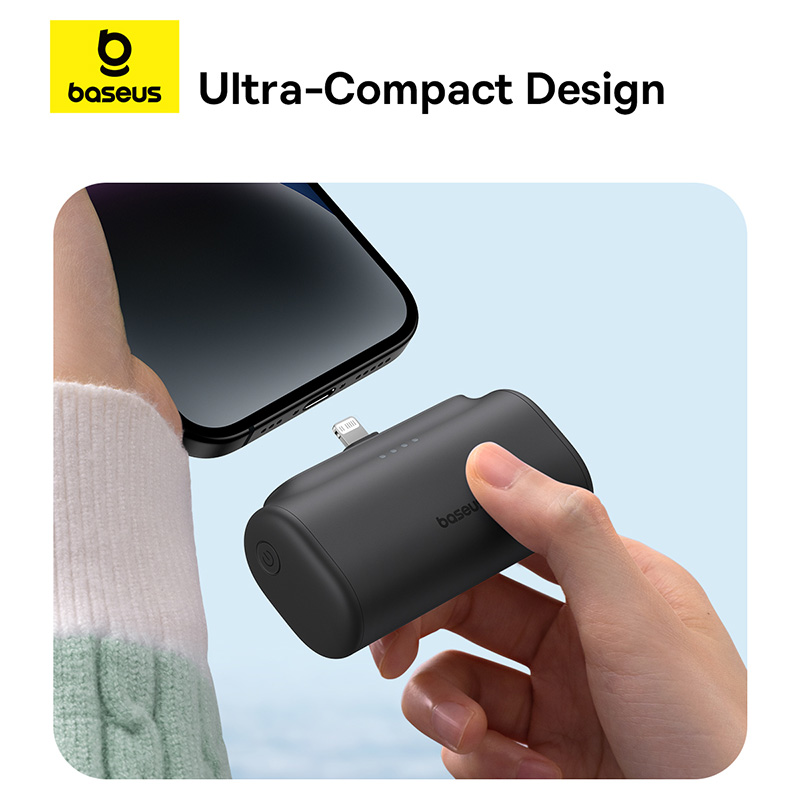 Egy fekete power bank egy kézzel egy telefonhoz csatlakoztatva. Baseus logó látható.