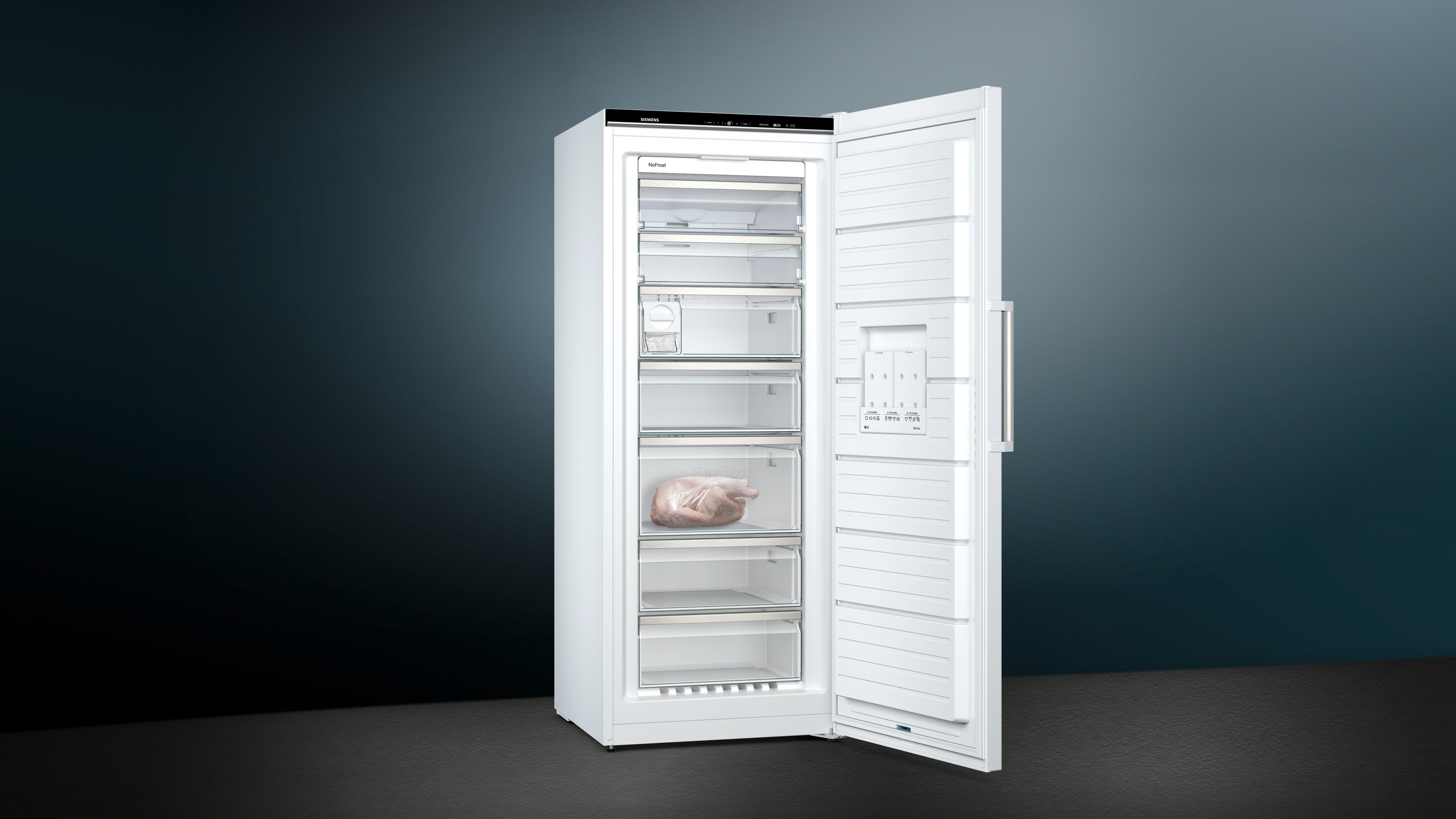 Weißer Siemens Gefrierschrank bei offener Tür. Eine Schublade enthält rohes Hähnchen.