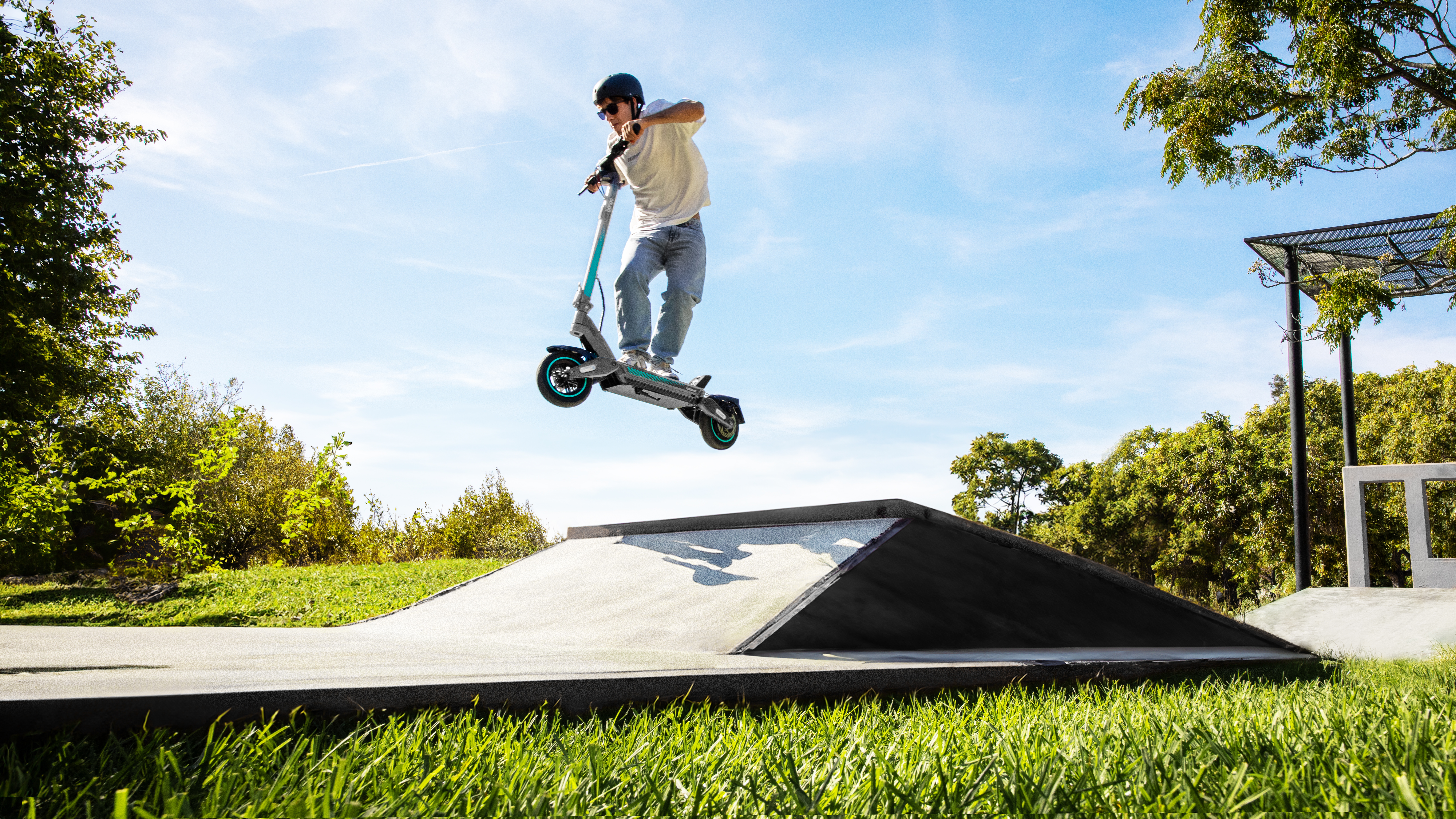 Persona saltando con un scooter en el aire en un skatepark.