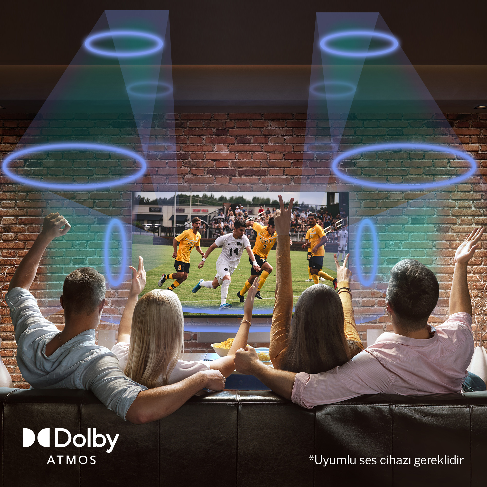 İnsanlar Dolby Atmos sesli bir futbol maçını televizyonda izliyor.