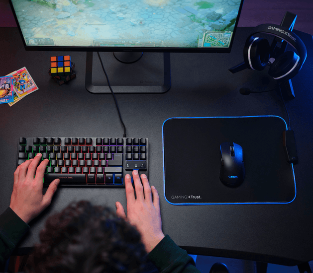 Egy gamer beállítás billentyűzettel, egérrel, egérpaddal, monitorral és fejhallgatóval.
