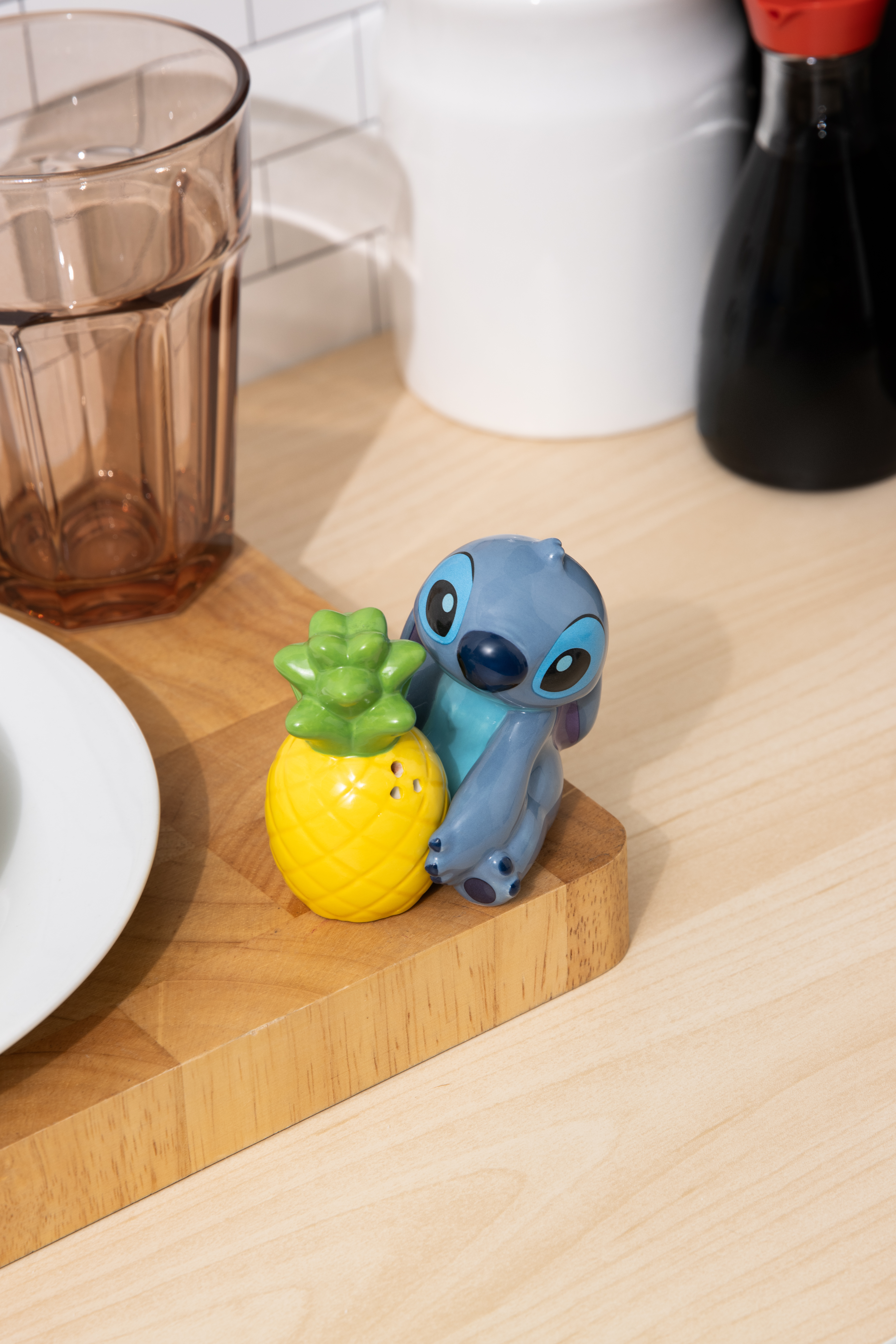 Stitch-Figur mit einem gelben Ananas-Salzstreuer.