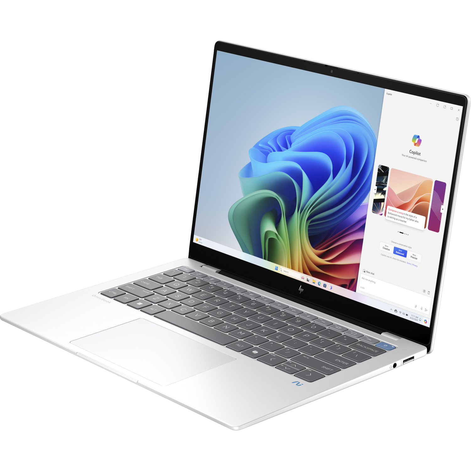 Silver laptop on a white surface, displaying a Copilot interface on its screen.