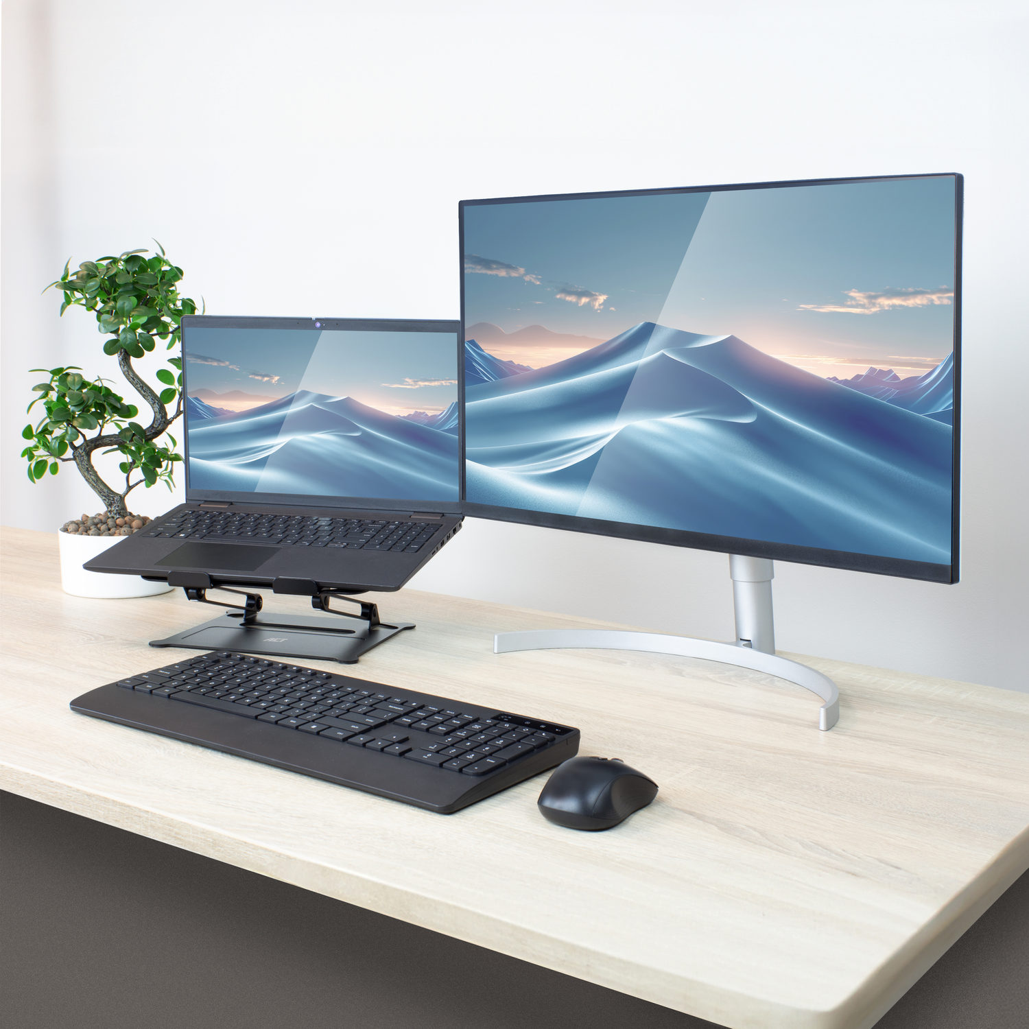 Laptop, monitor, toetsenbord, muis op een bureau.
