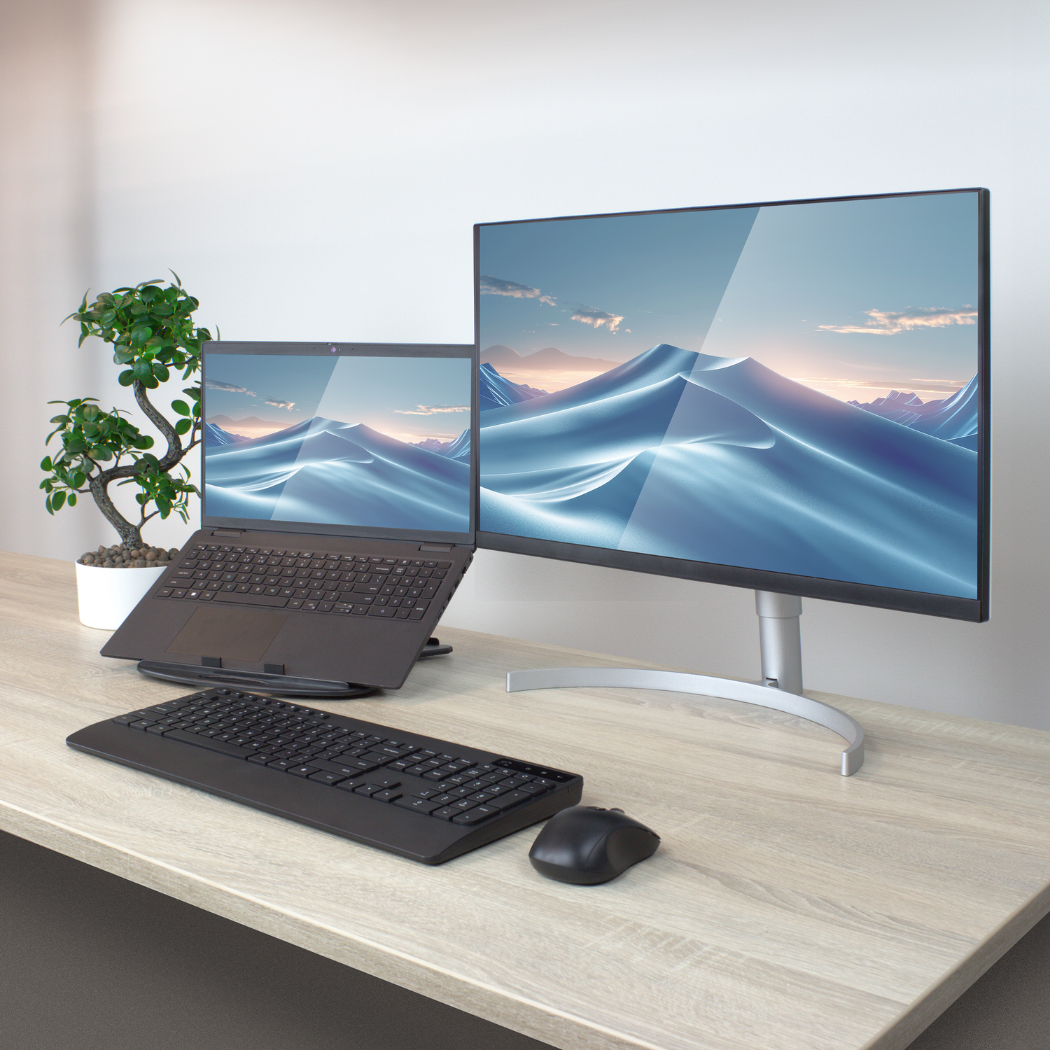 A modern workspace with a laptop, monitor, keyboard, and mouse on a desk.