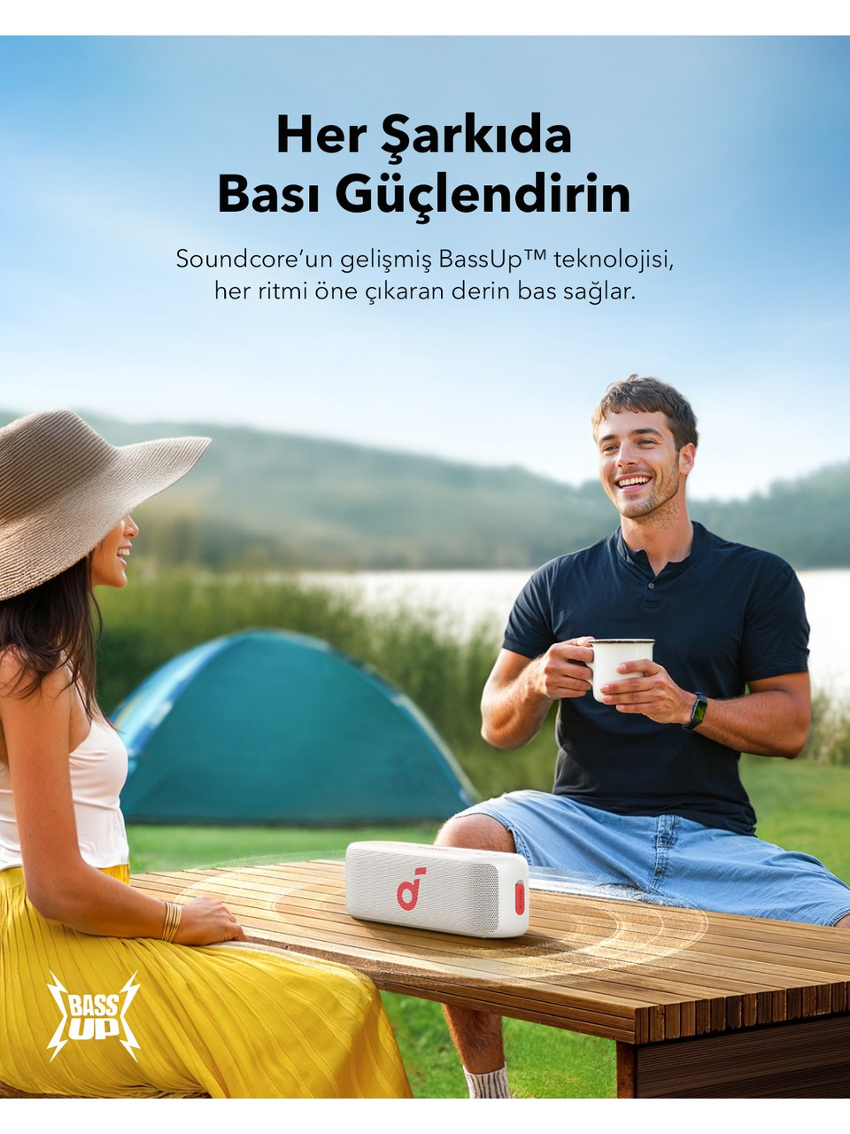 Adam ve kadın masada oturuyor. Önünde beyaz hoparlör. Yukarıda metin. Arka planda yeşil manzara.