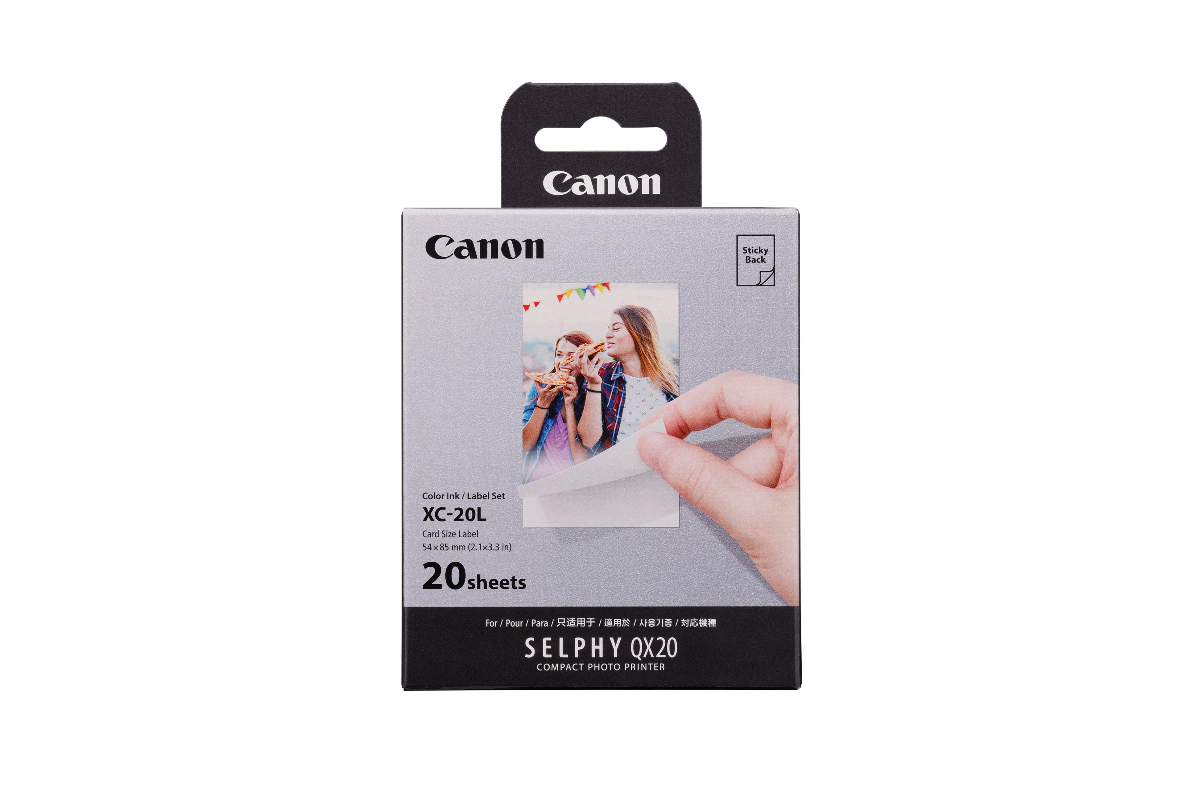 Canon Fotopapierpackung mit einer Frau, die einen Aufkleber abzieht. Text: SELPHY OX20, 20 Blatt.