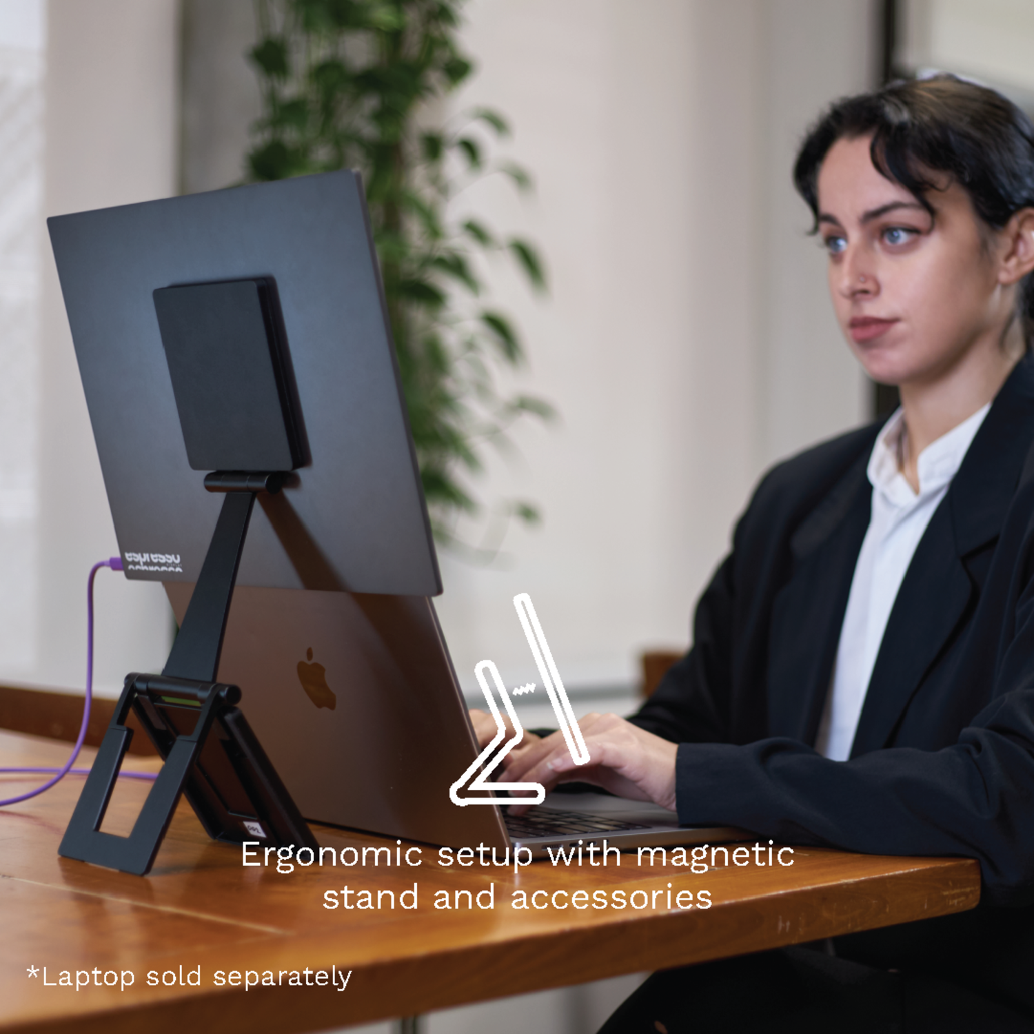 Woman using laptop on a wooden desk with a magnetic stand. Text: 'Ergonomic setup with magnetic stand'.